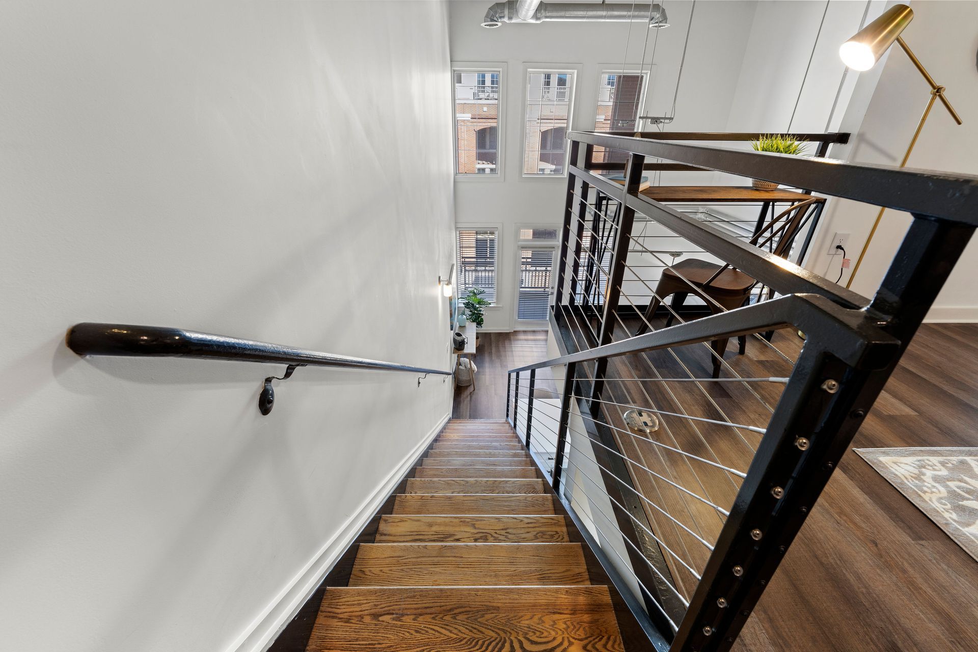 A wooden staircase with a metal railing leading up to the second floor of a house.