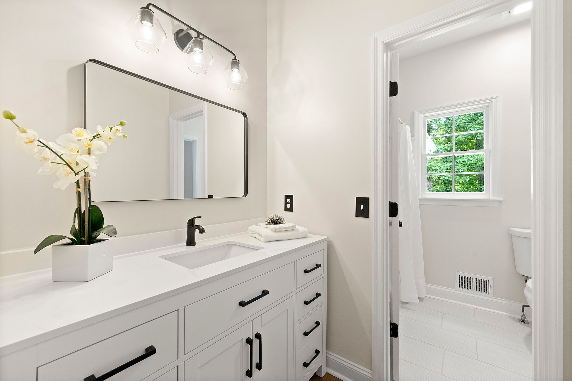 A bathroom with a sink , mirror , and toilet.