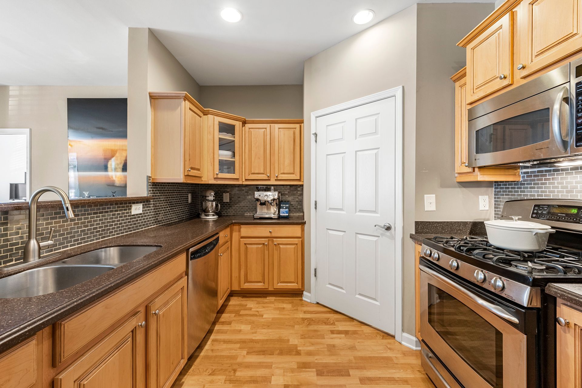 A kitchen with stainless steel appliances and wooden cabinets.