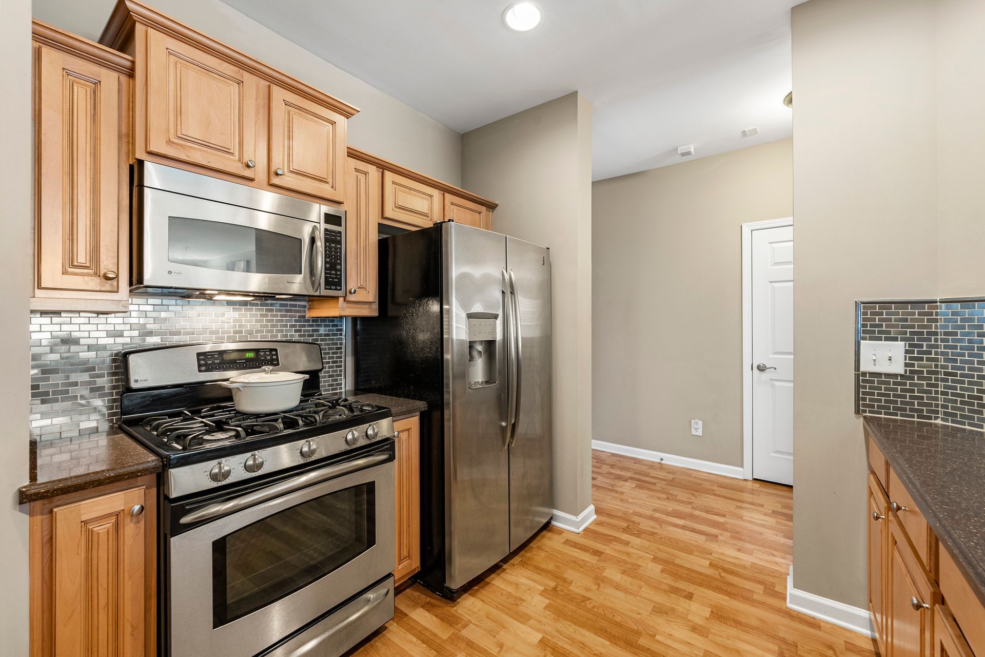 A kitchen with stainless steel appliances and wooden cabinets.