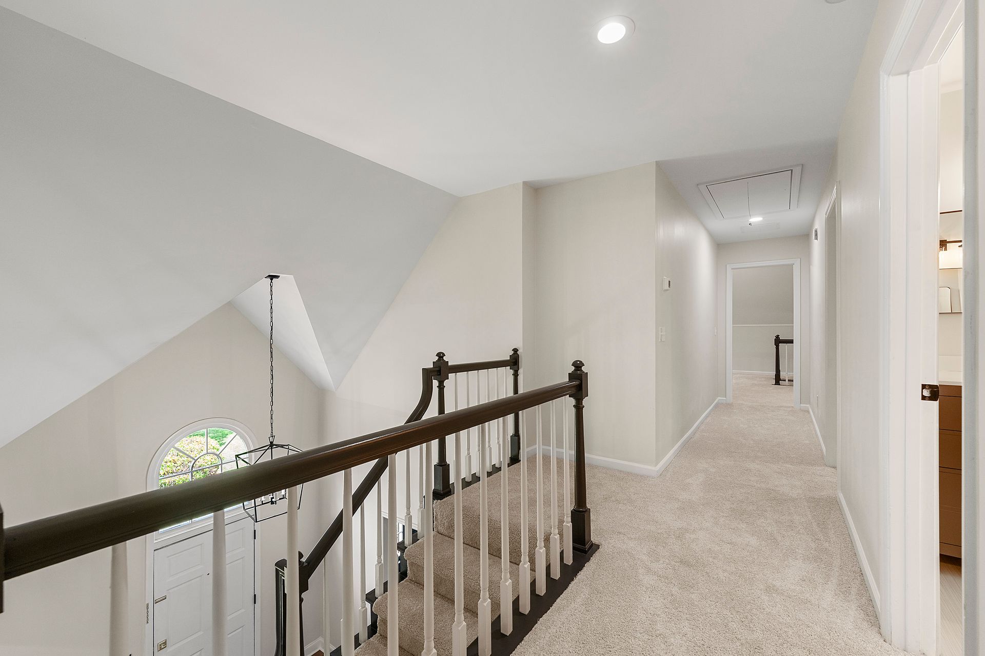 A hallway with a staircase leading up to the second floor of a house.