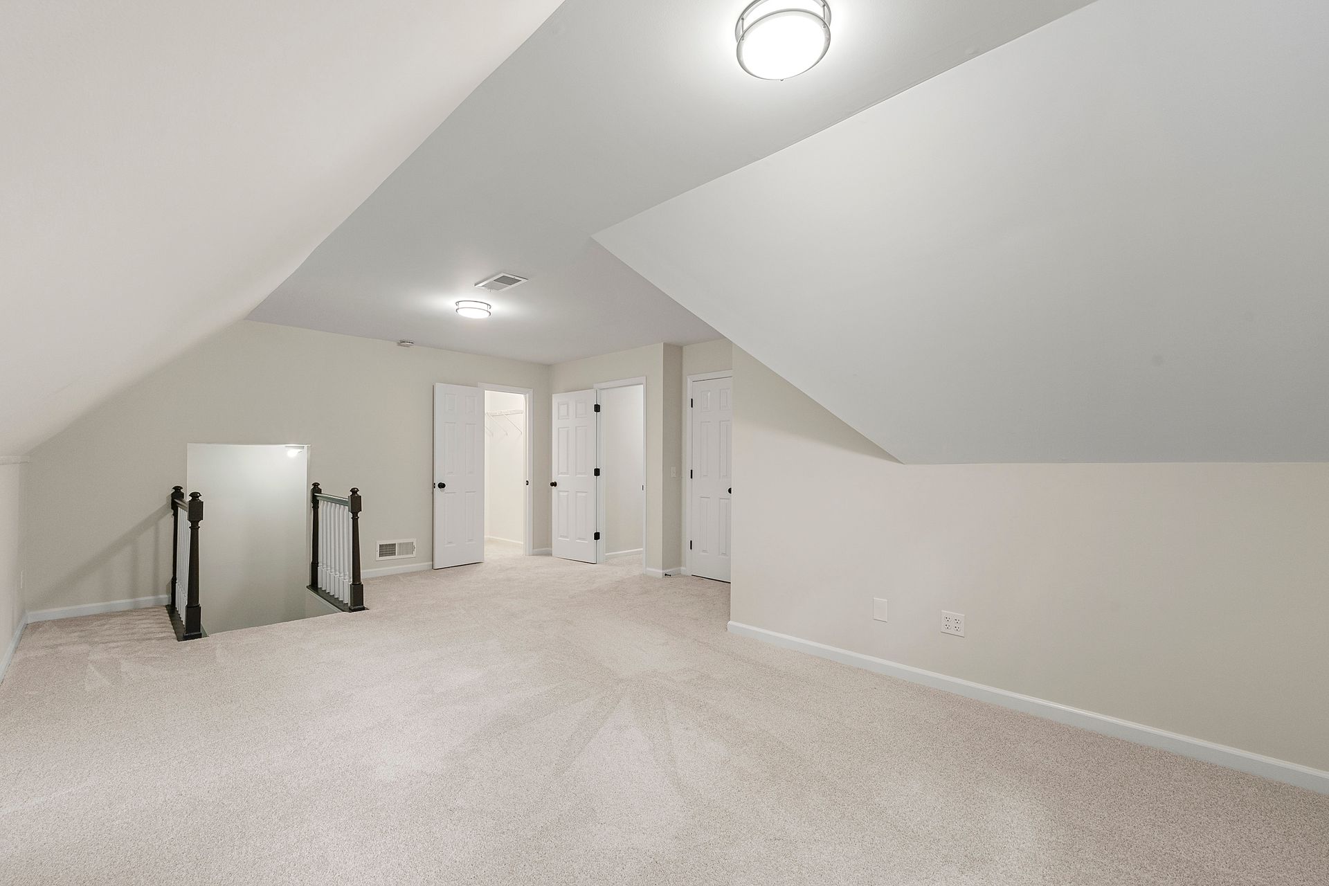 An empty attic with a staircase leading up to the second floor.