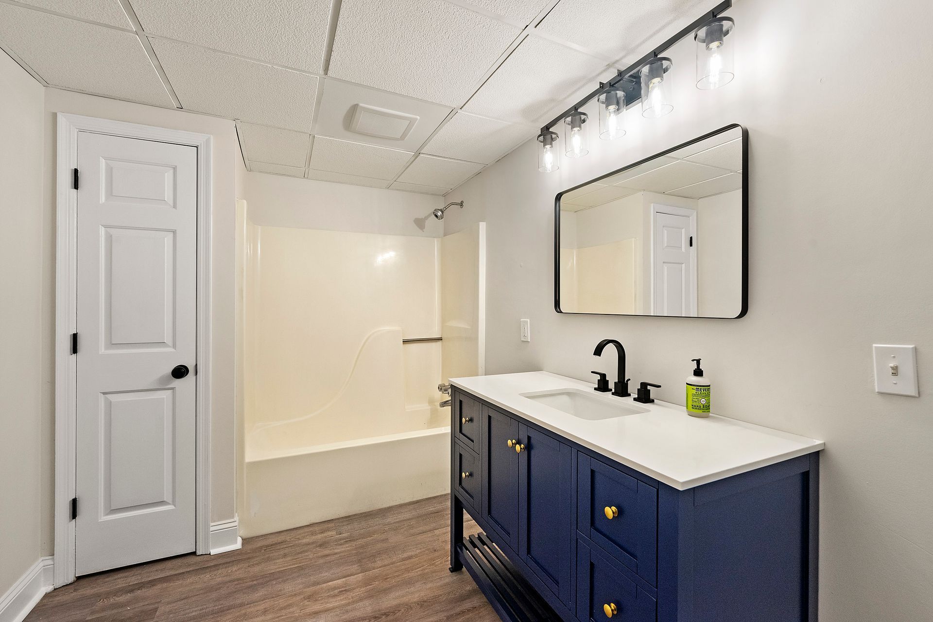 A bathroom with two sinks , a mirror and a bathtub.