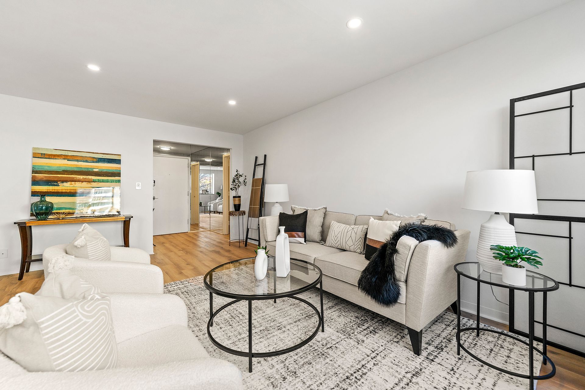 A living room with a couch , chairs , and a coffee table.