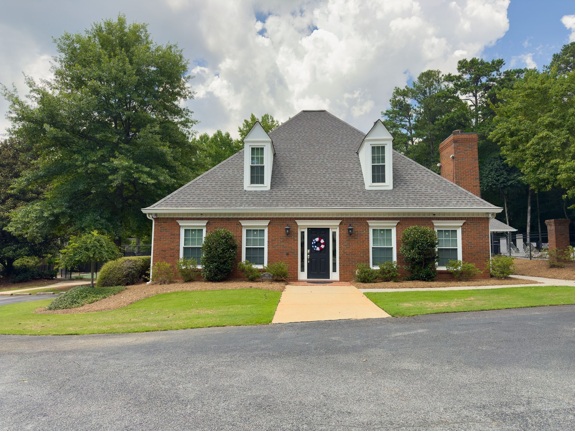 A brick house with a gray roof and white trim