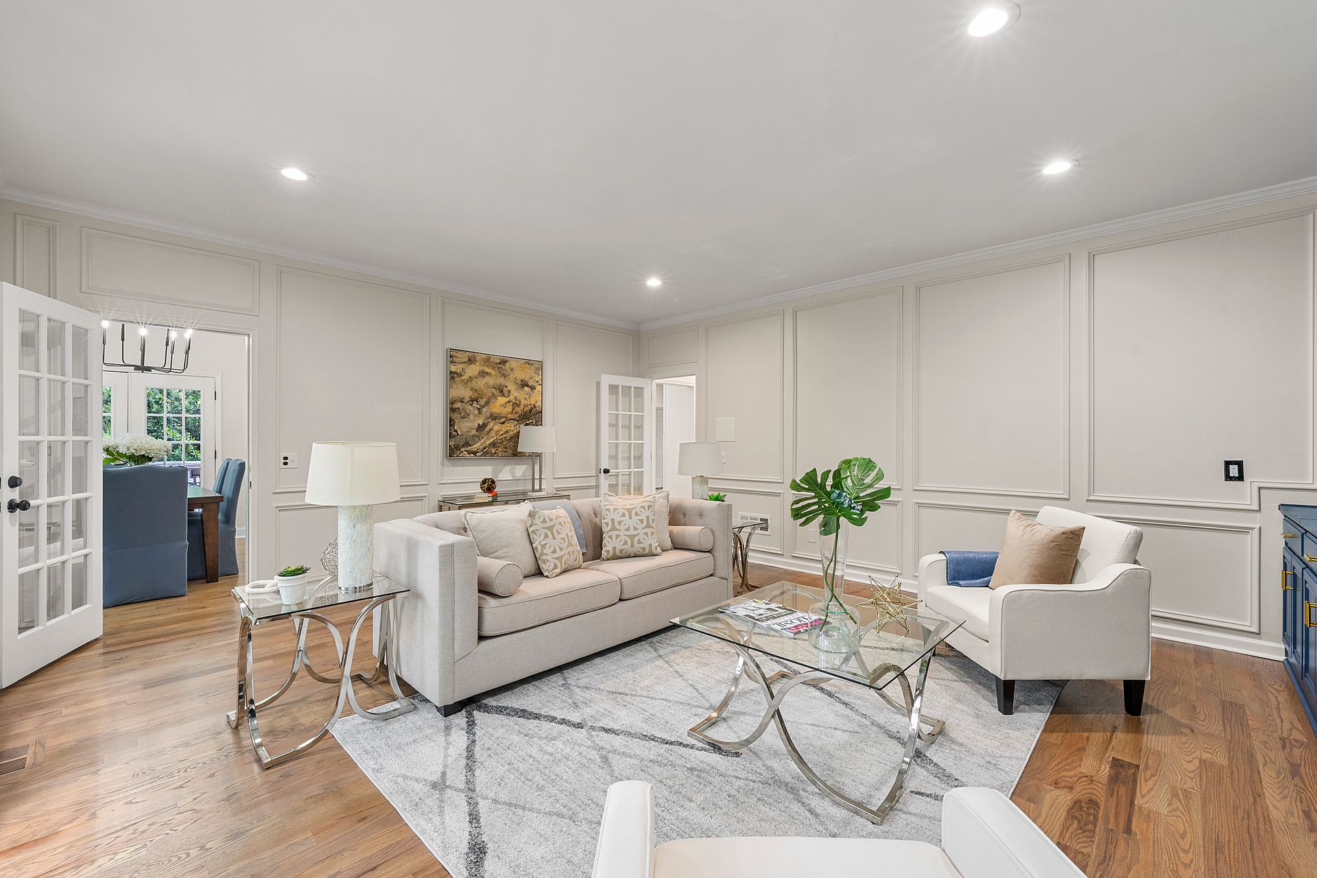 A living room with a couch , chair , coffee table and rug.