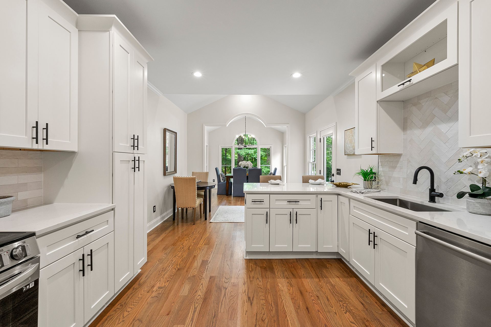A kitchen with white cabinets , stainless steel appliances , and hardwood floors.
