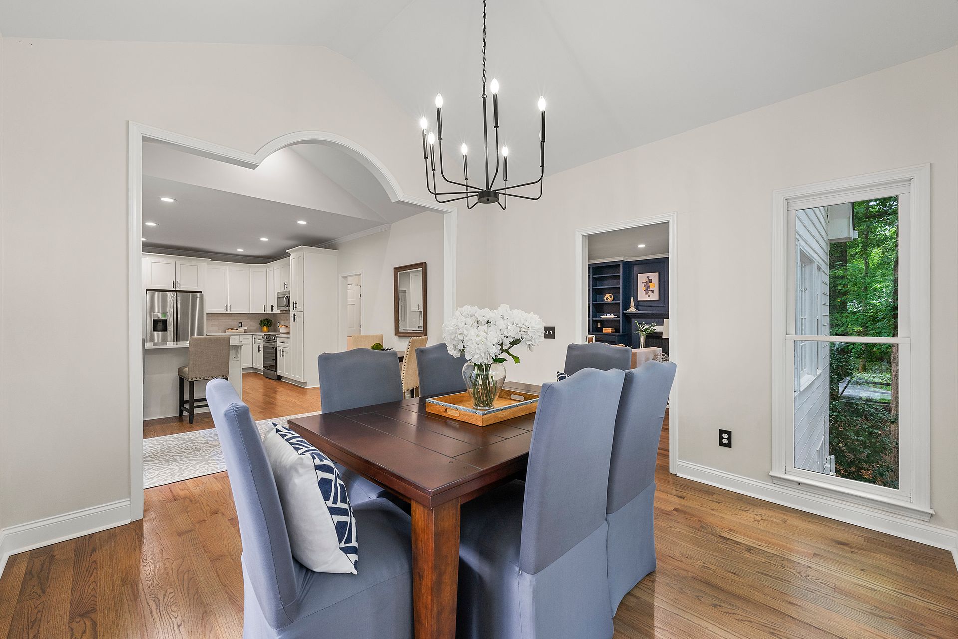 A dining room with a table and chairs and a chandelier.