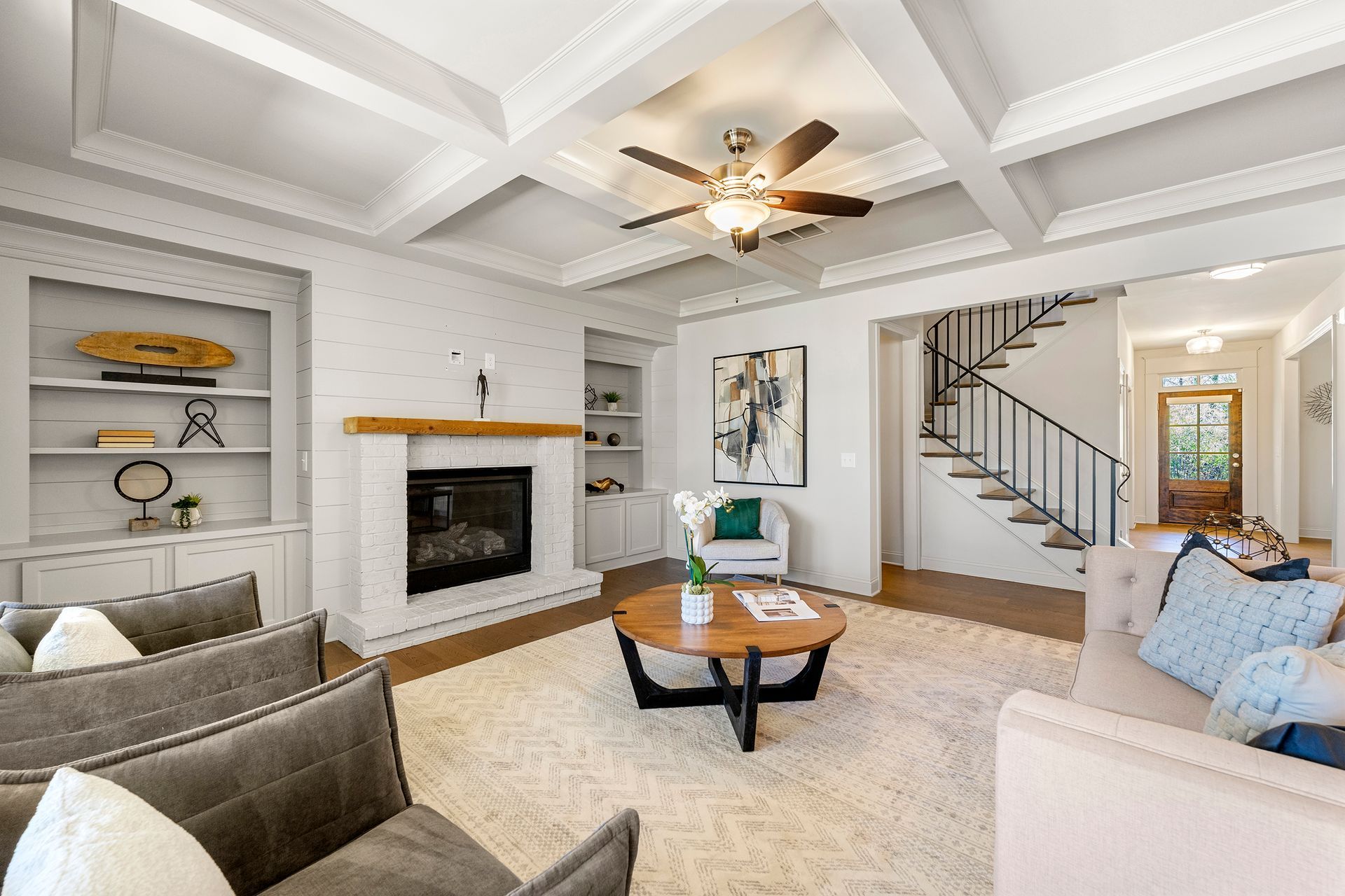 A living room filled with furniture and a fireplace with a ceiling fan.