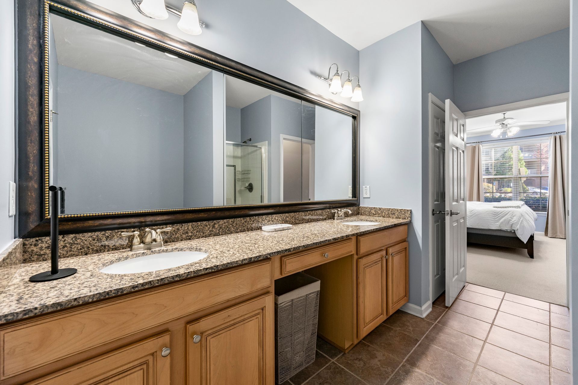 A bathroom with two sinks and a large mirror.