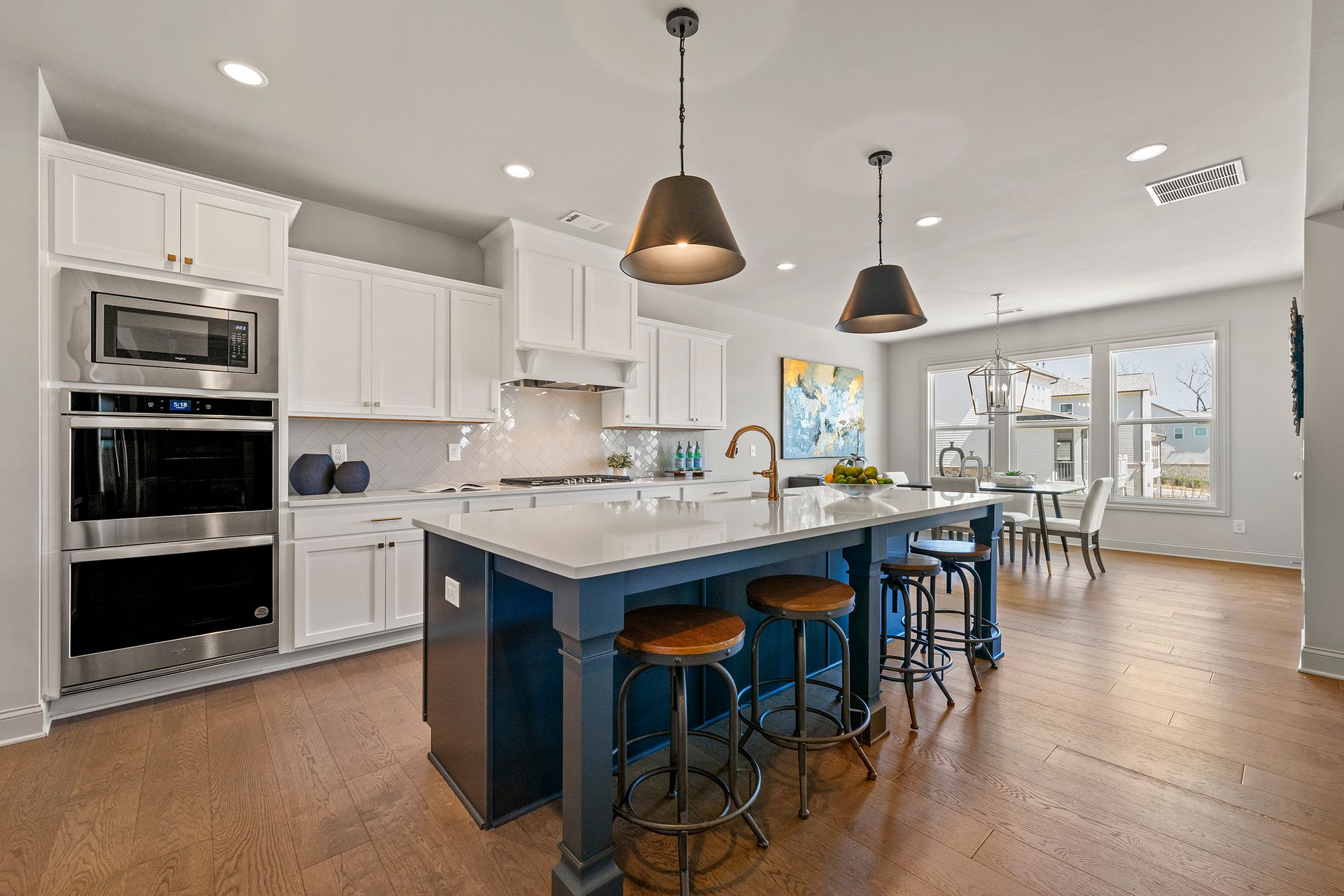 A kitchen with a large blue island and white cabinets