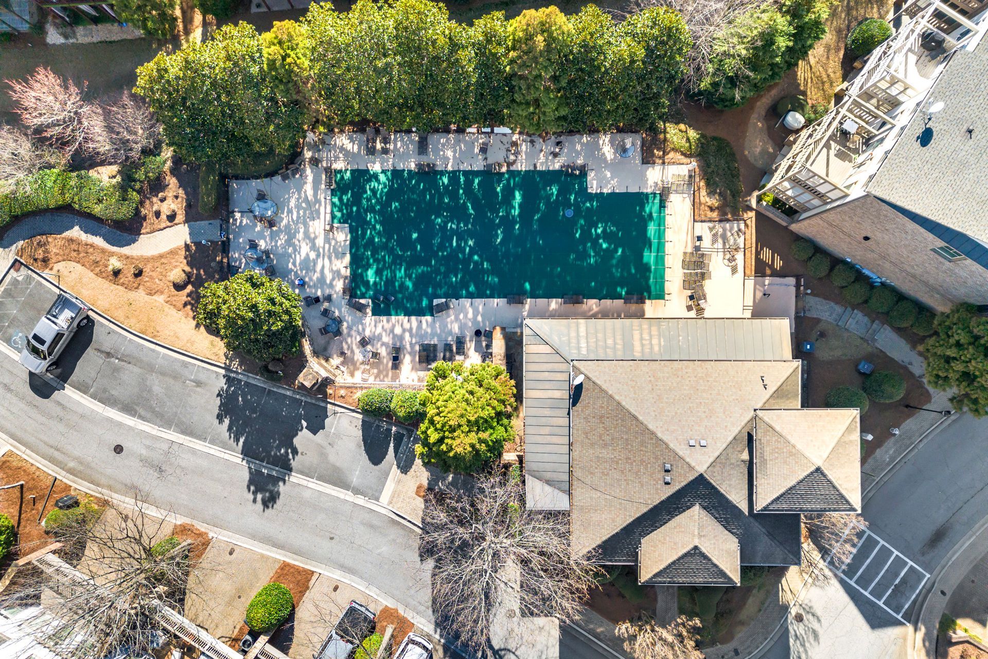 An aerial view of a large swimming pool surrounded by trees.