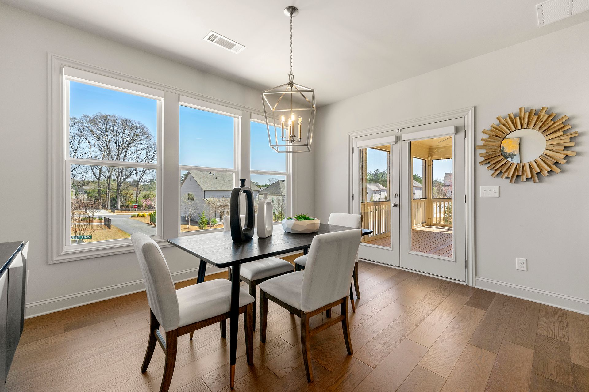 A dining room with a table and chairs and lots of windows.