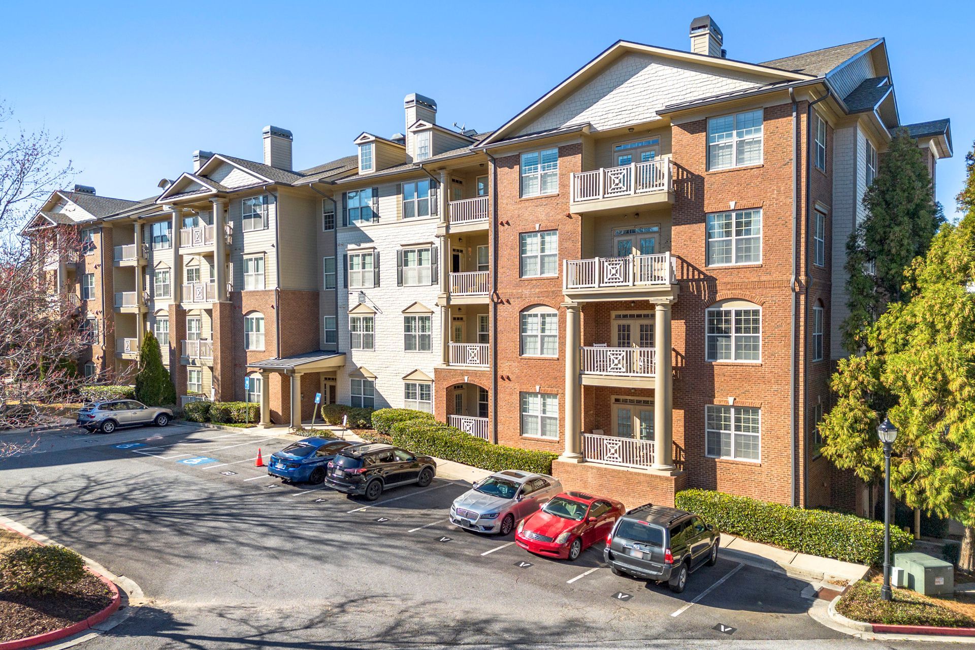 A large apartment building with cars parked in front of it.