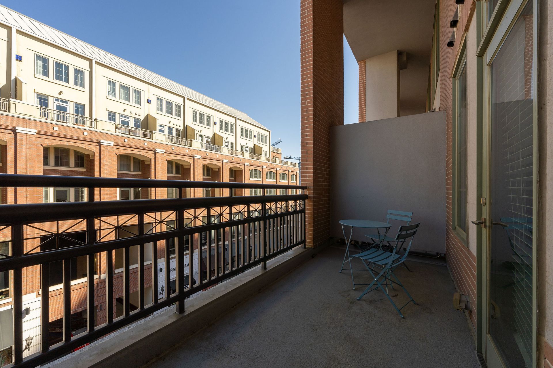 A balcony with a table and chairs in front of a building