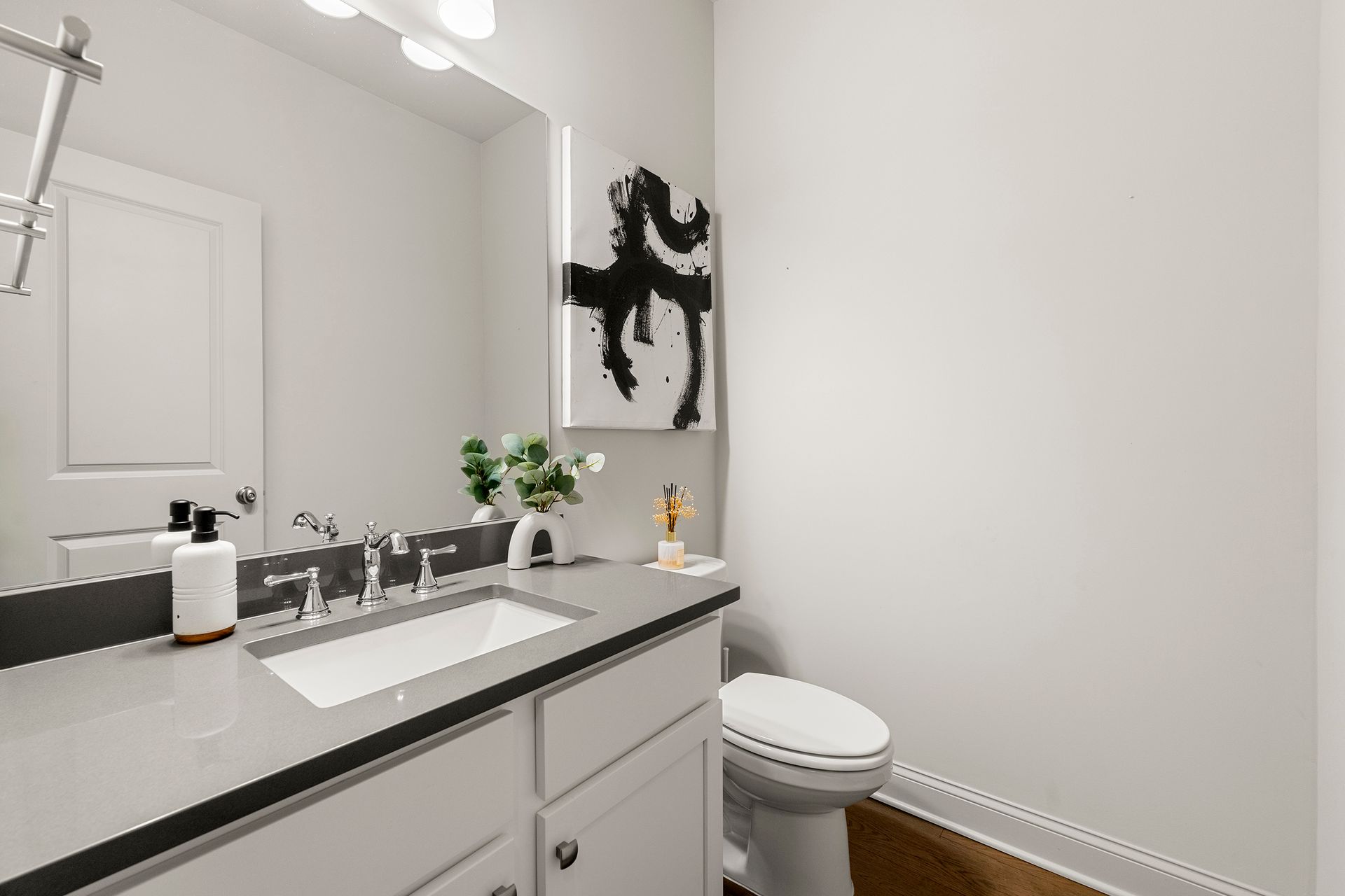 A bathroom with a sink , toilet and mirror.
