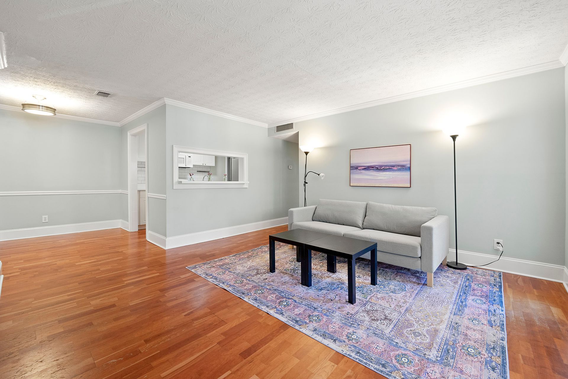 A living room with a couch , coffee table , and rug.