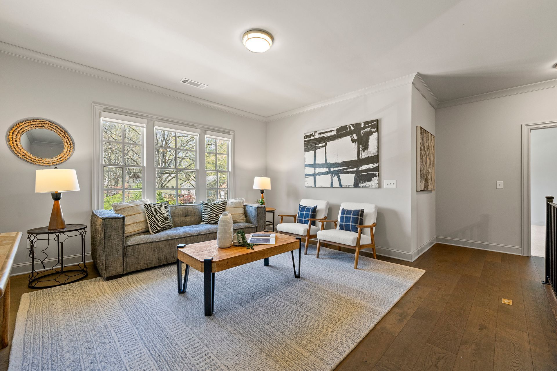 A living room with a couch , chairs , and a coffee table.