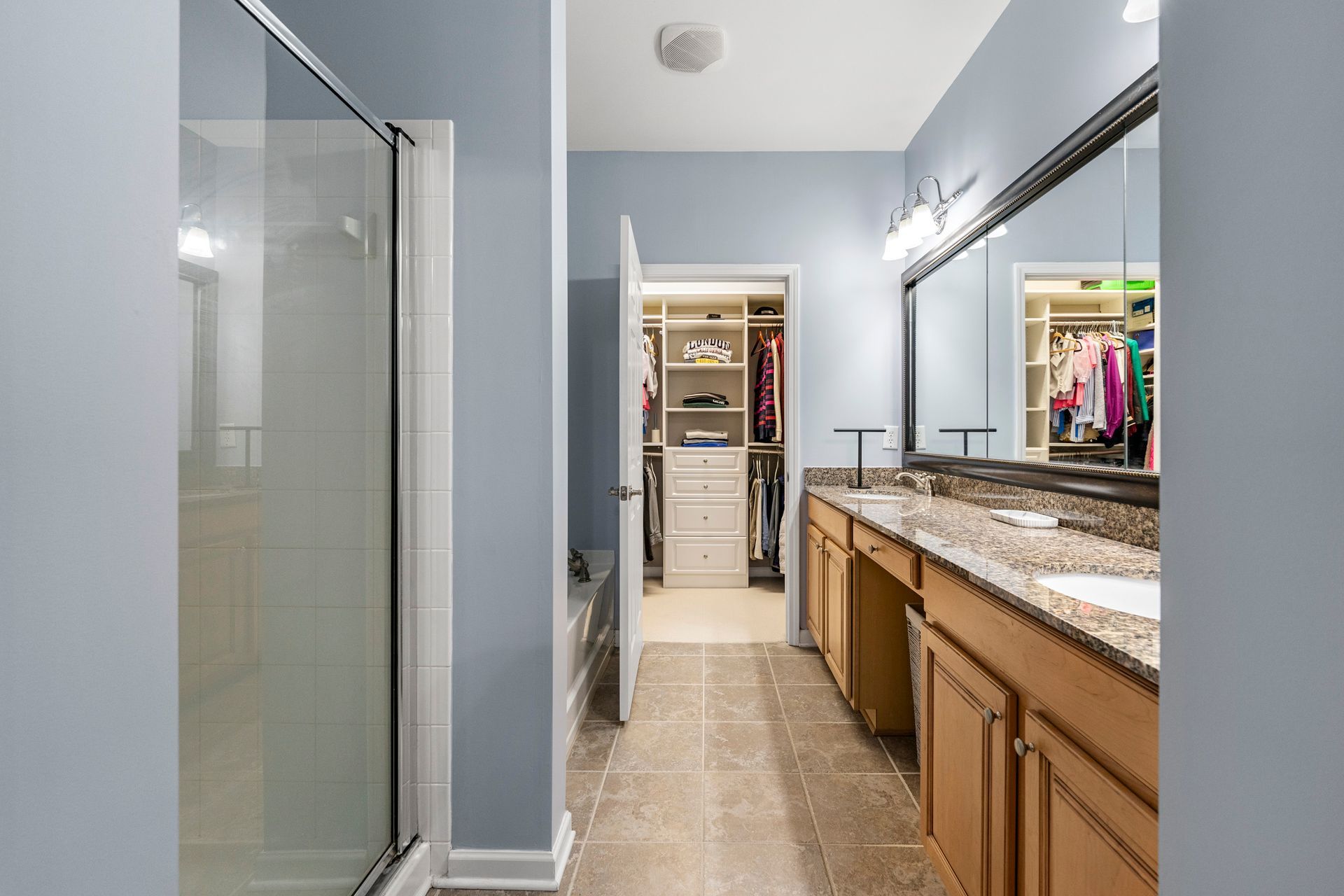 A bathroom with two sinks and a walk in closet