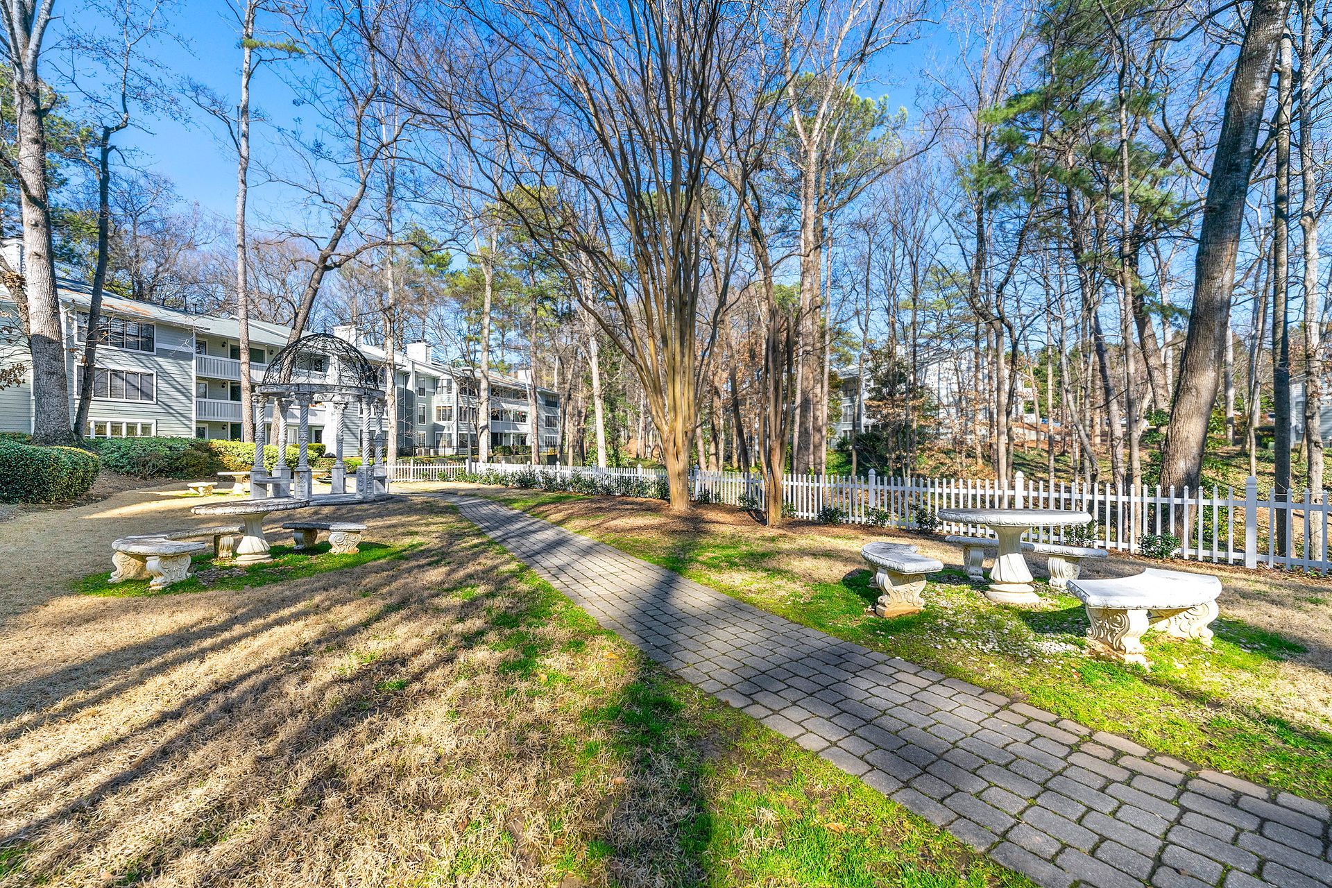 A picnic area with tables and benches in the middle of a park.