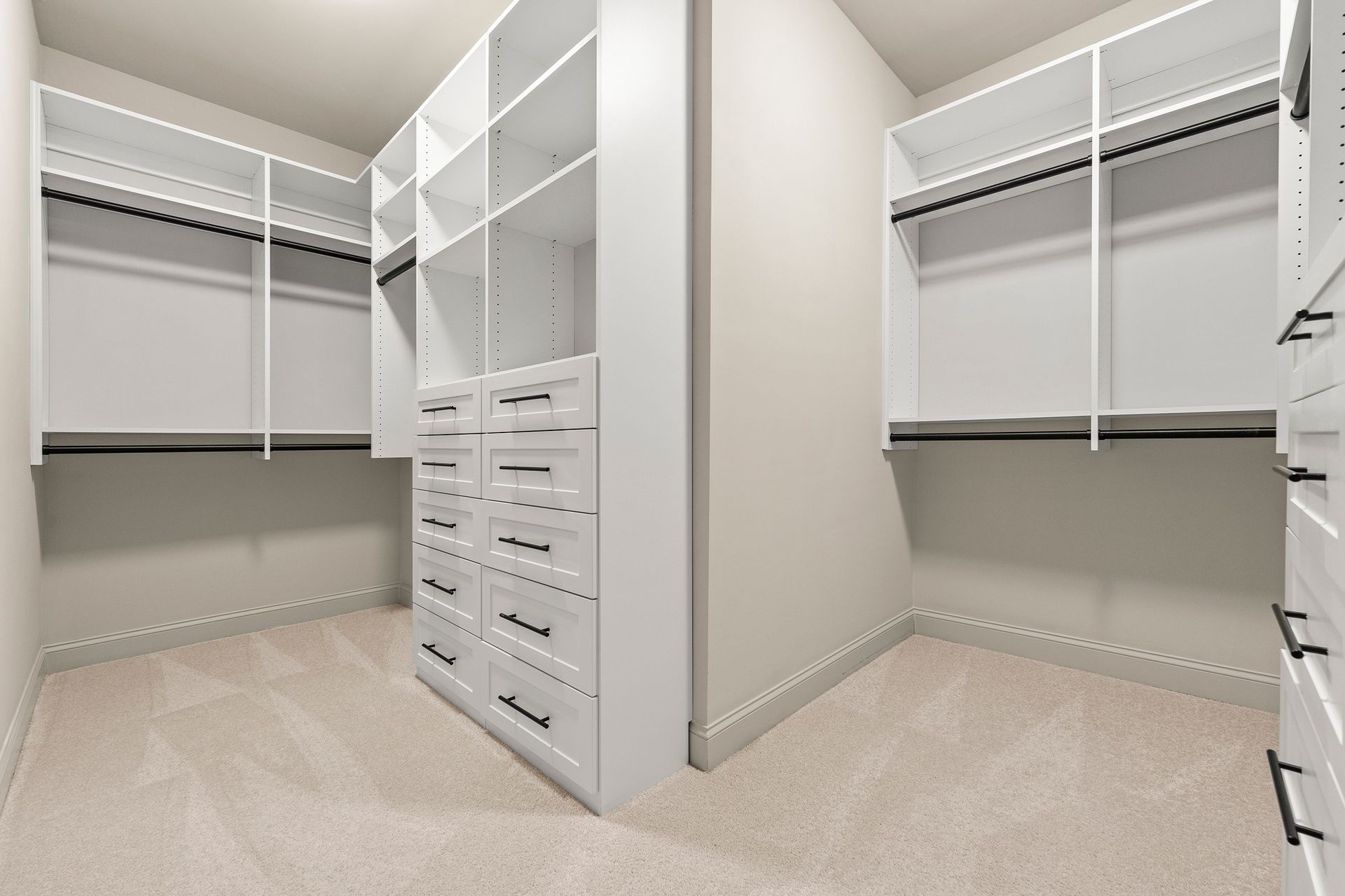A walk in closet with lots of shelves and drawers.