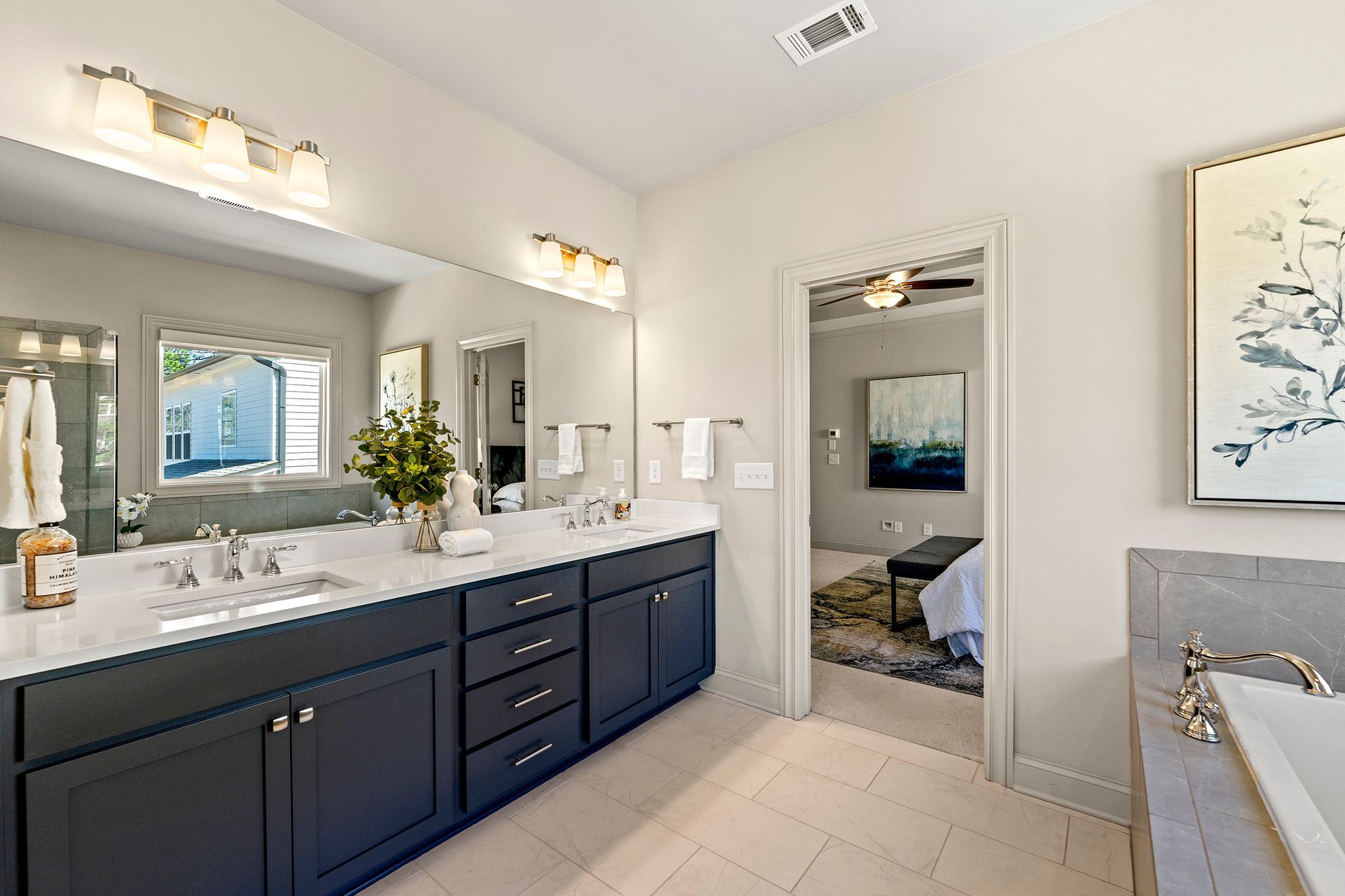 A bathroom with two sinks , two mirrors and a bathtub.