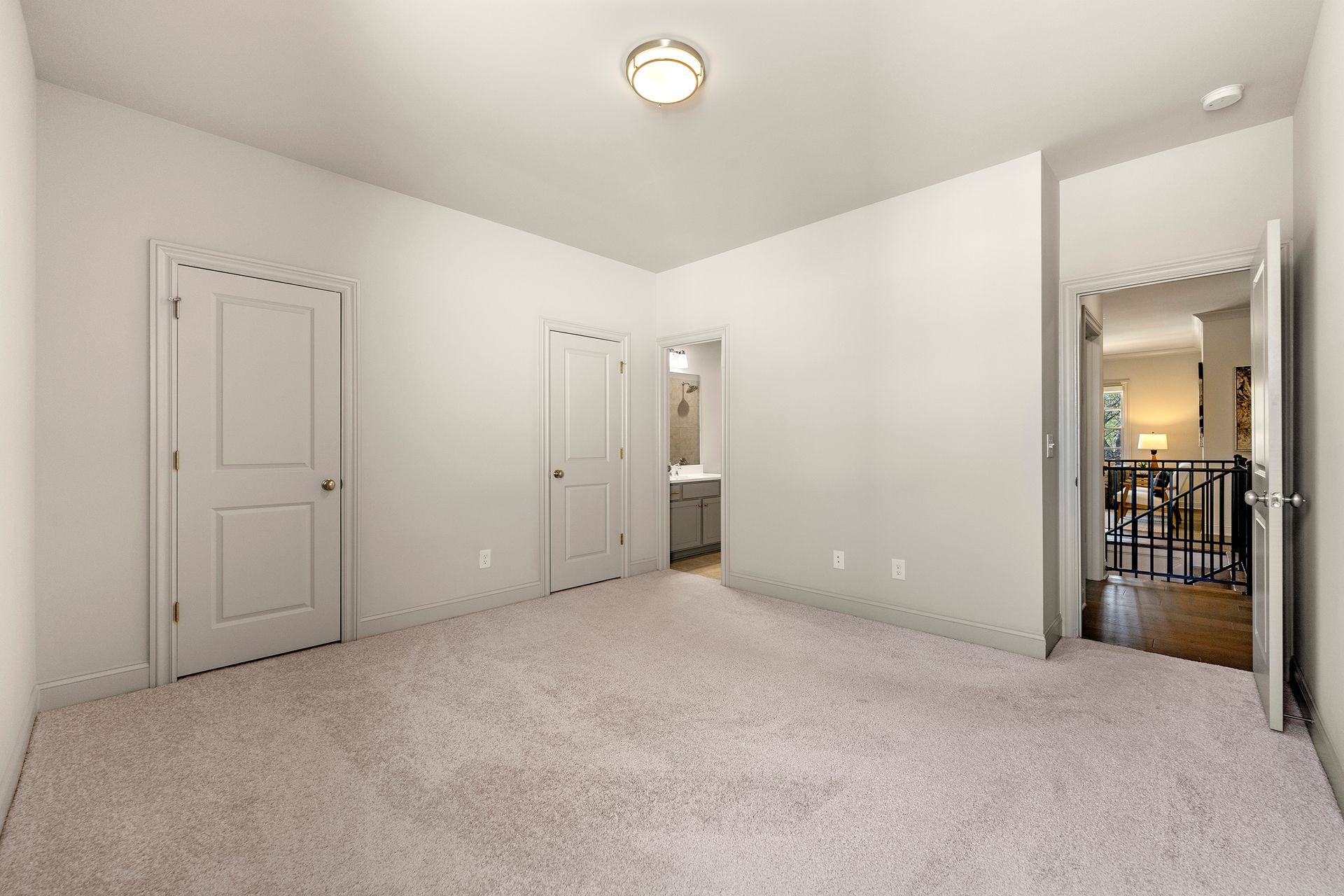 An empty bedroom with a carpeted floor and white walls.