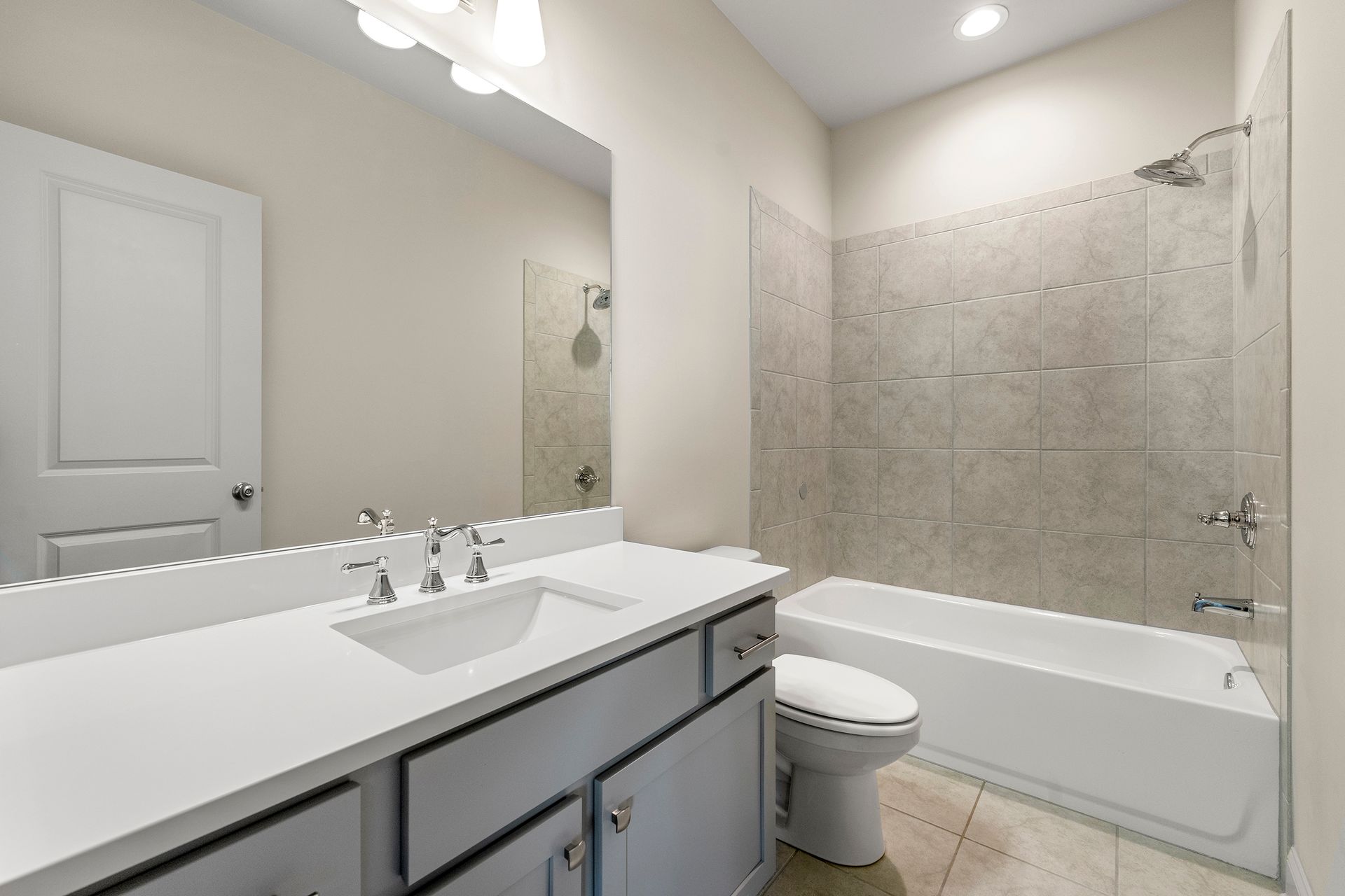 A bathroom with a sink , toilet , tub and mirror.