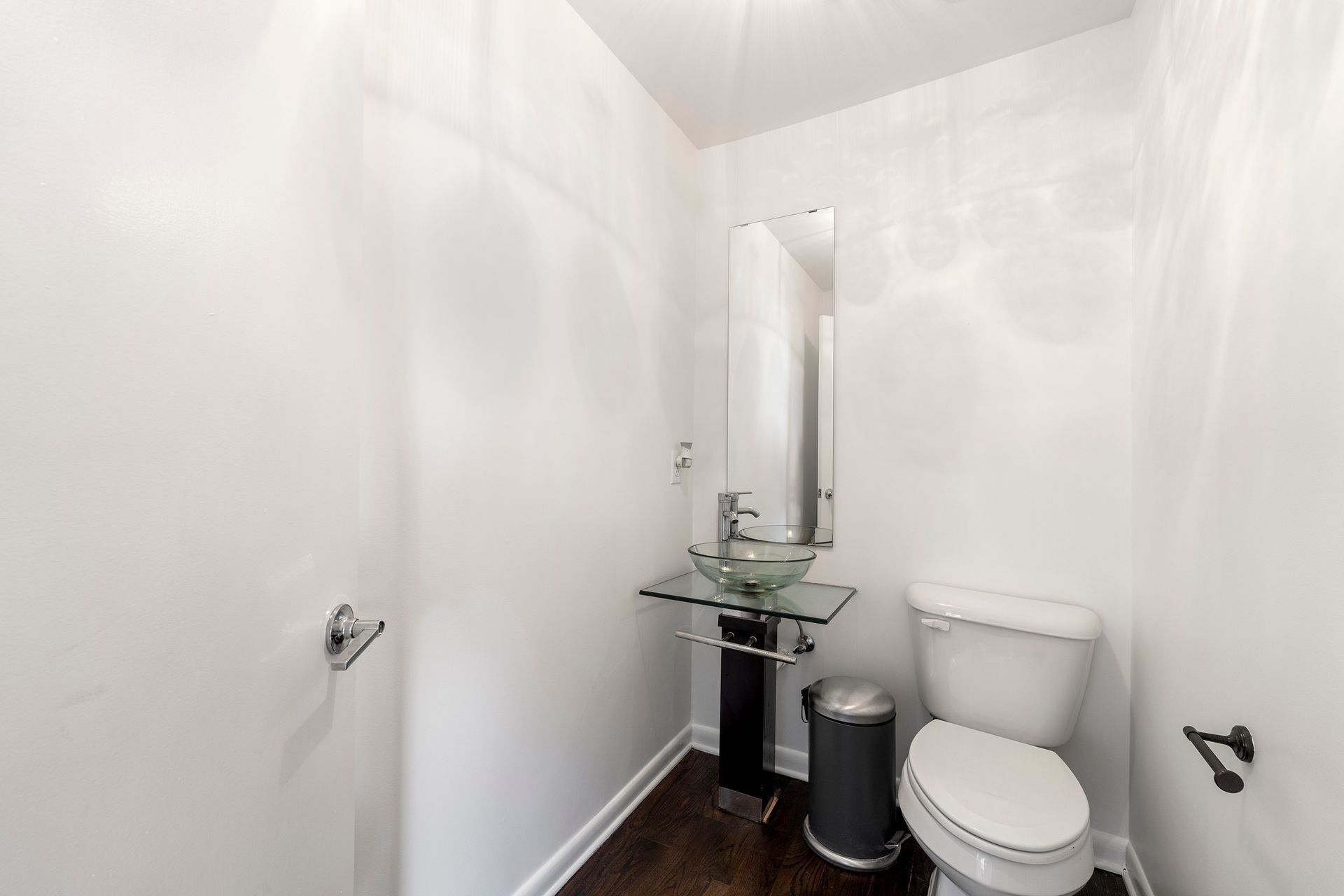 A bathroom with a toilet , sink and mirror.