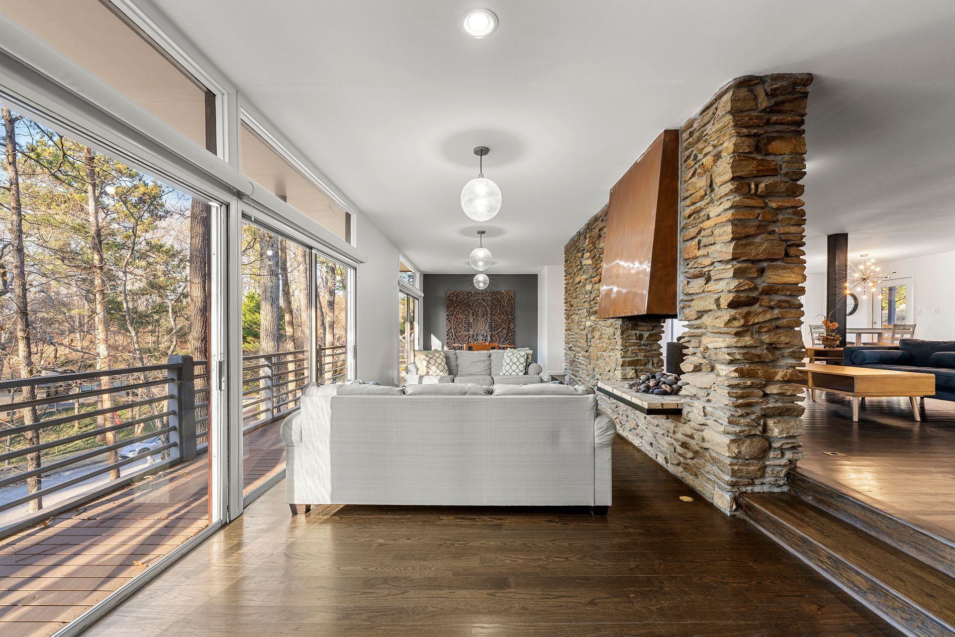 A living room with a couch , fireplace , and sliding glass doors.