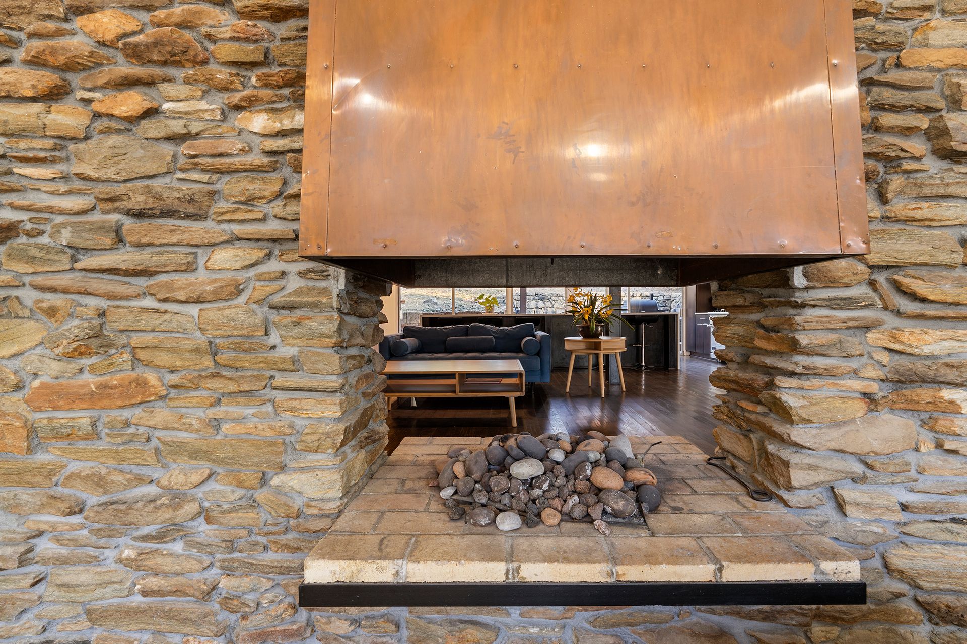 There is a fireplace in the middle of a stone wall.