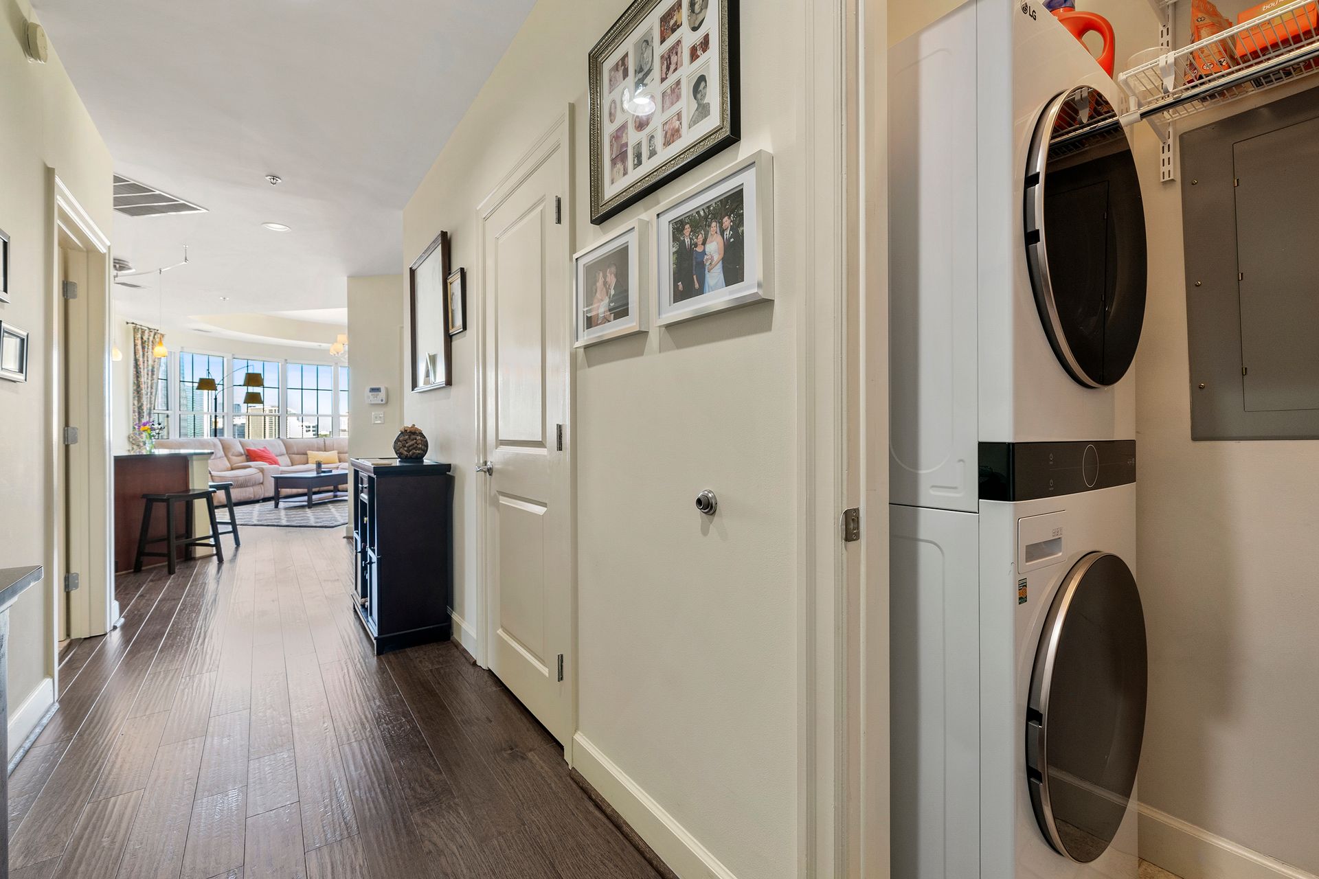 A hallway with a washer and dryer stacked on top of each other.