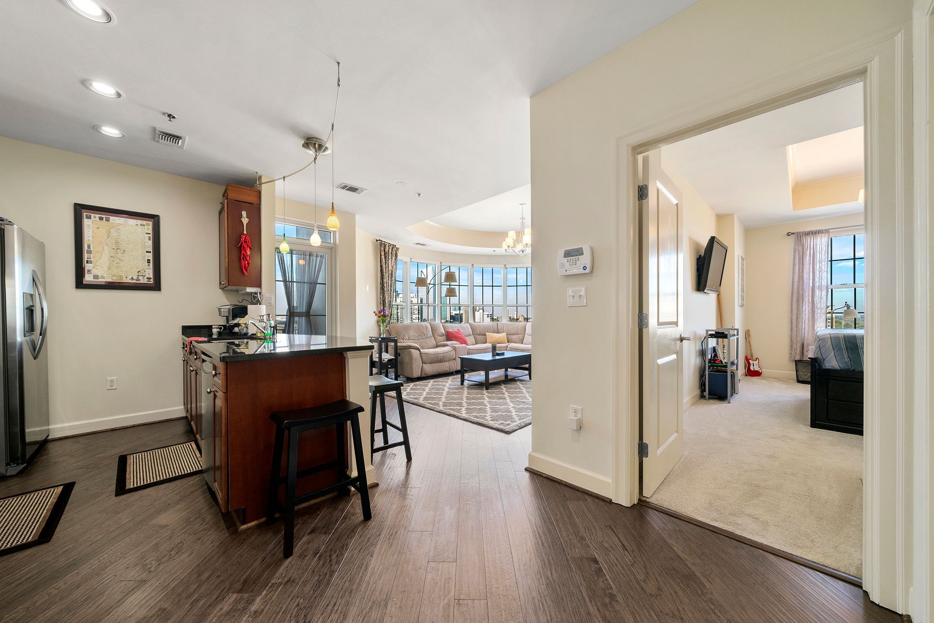 A kitchen and living room in a house with hardwood floors