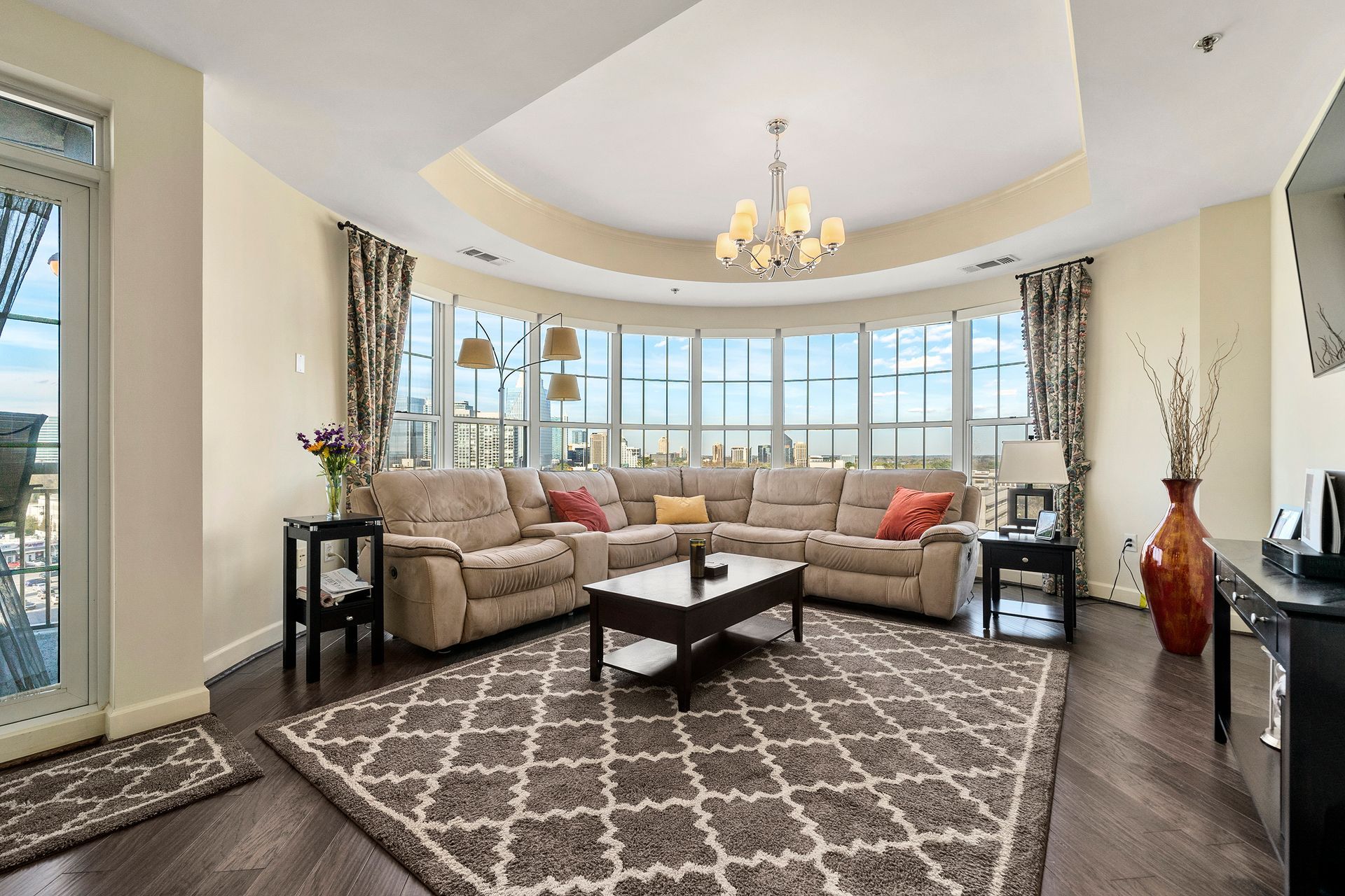 A living room with a large sectional couch and a rug