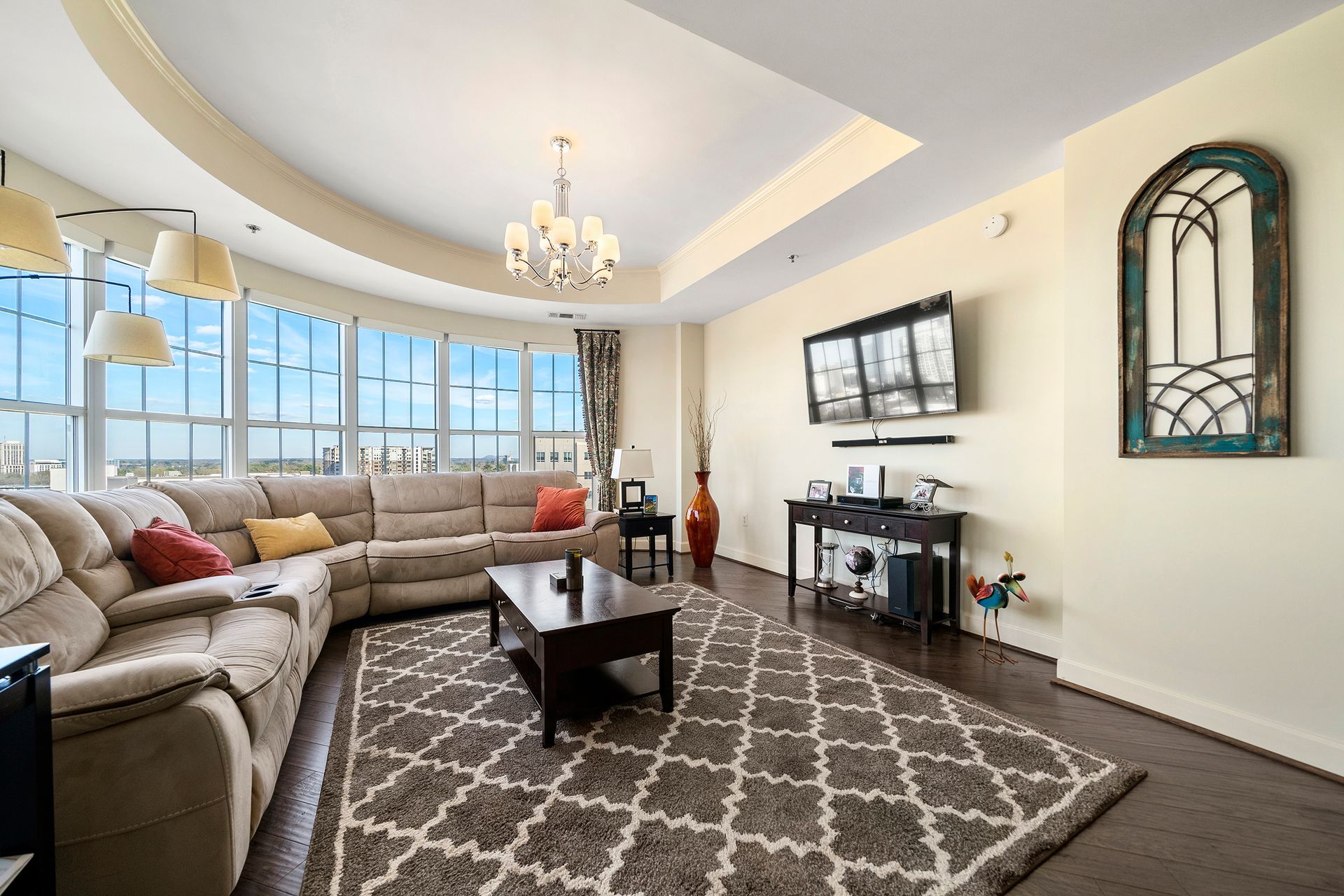 A living room with a large sectional couch , coffee table , and television.