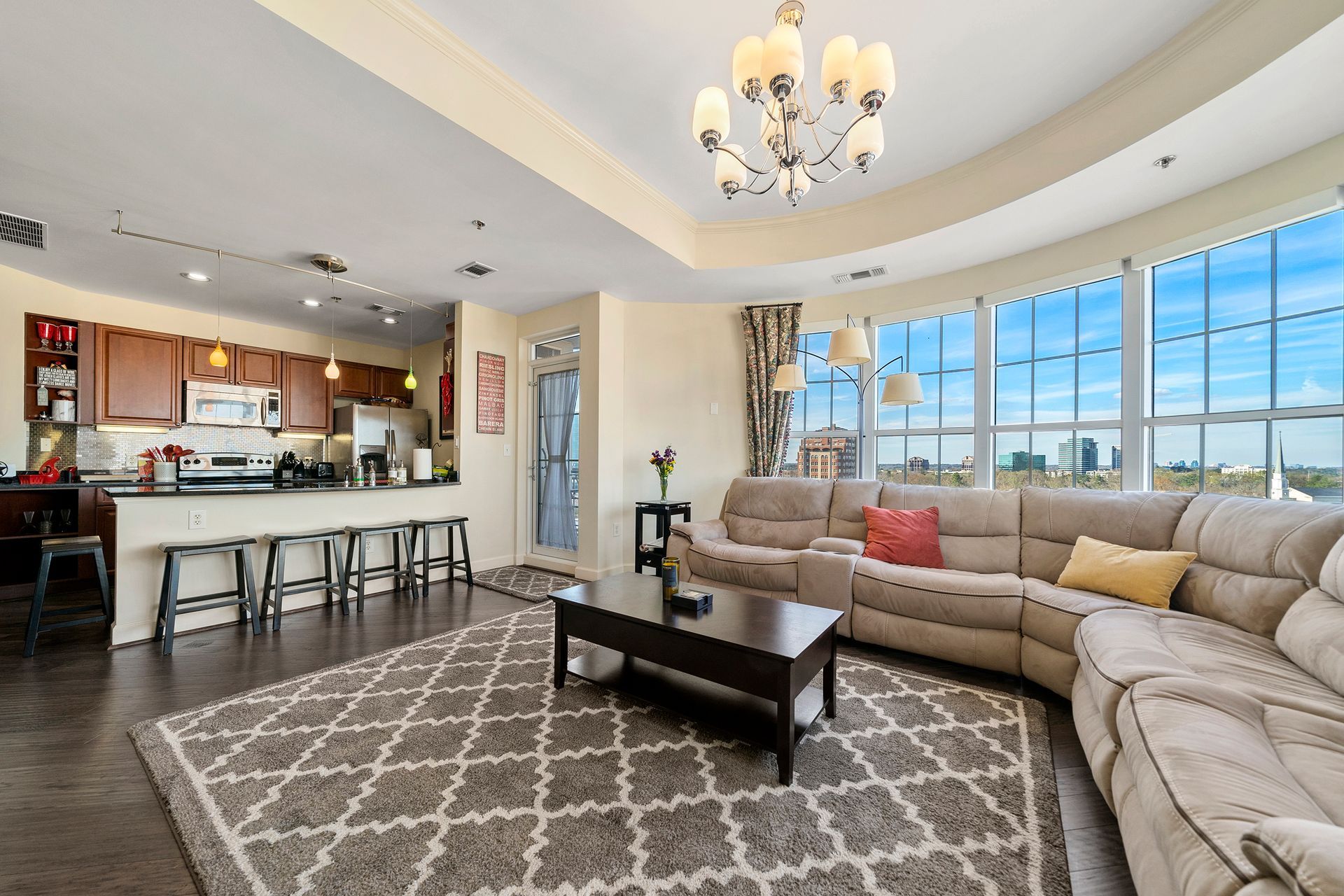 A living room with a couch , coffee table , and chandelier.