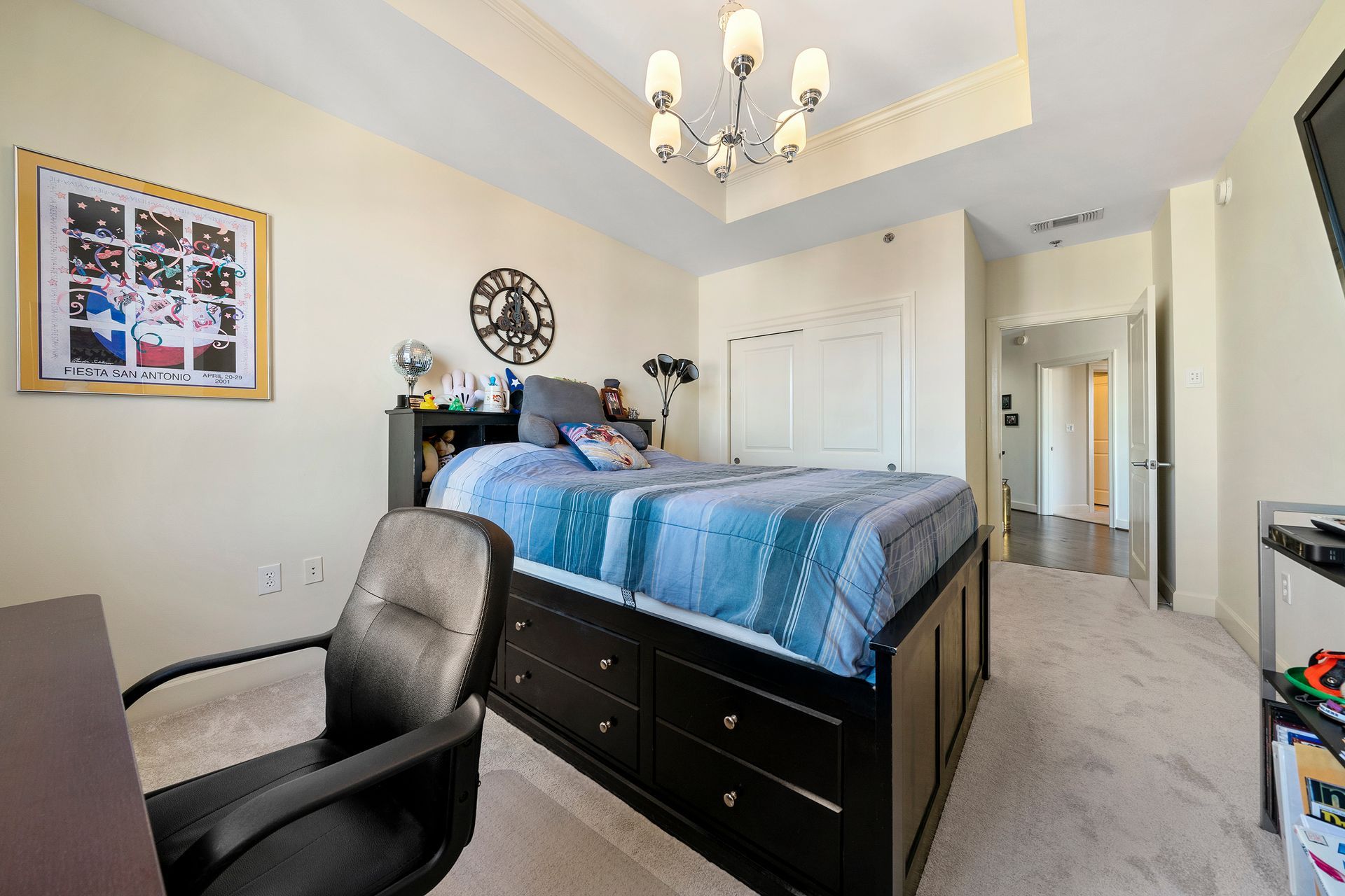 A bedroom with a large bed , desk and chair.