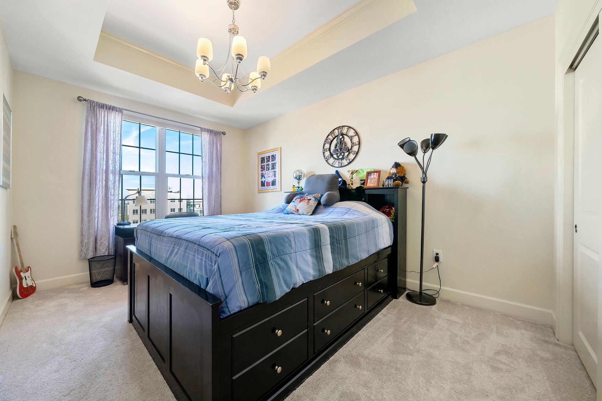 A bedroom with a large bed and a chandelier.