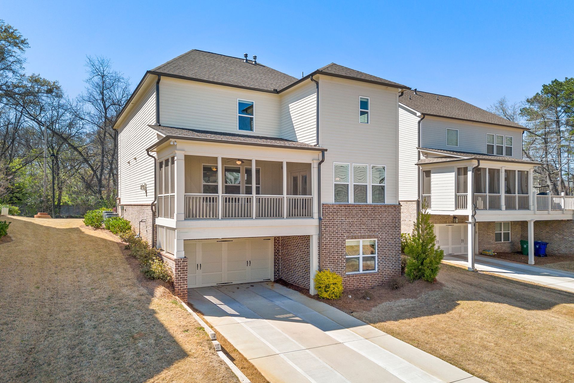 A large white house with a lot of windows and a driveway leading to it.