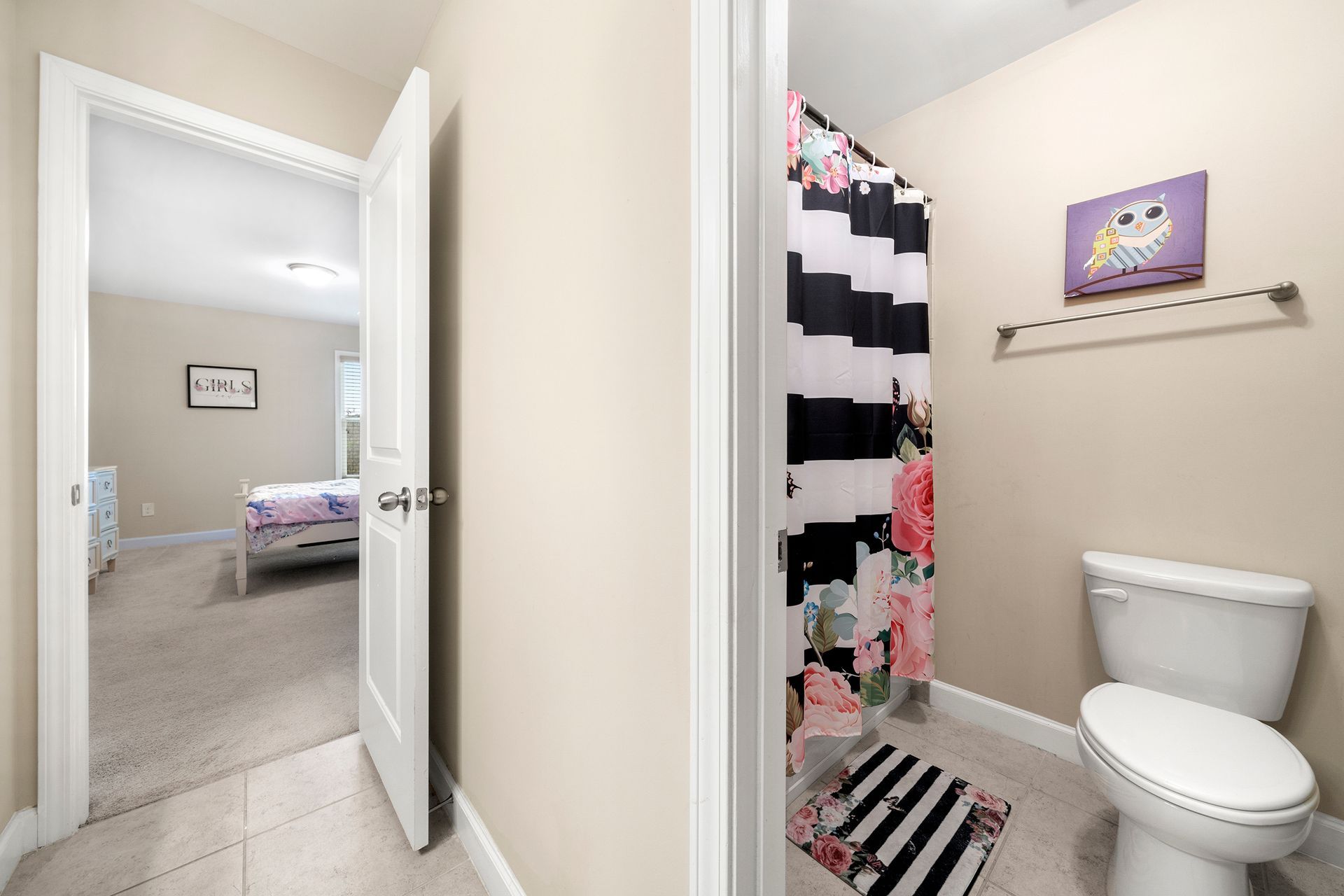 A bathroom with a toilet and a shower curtain.