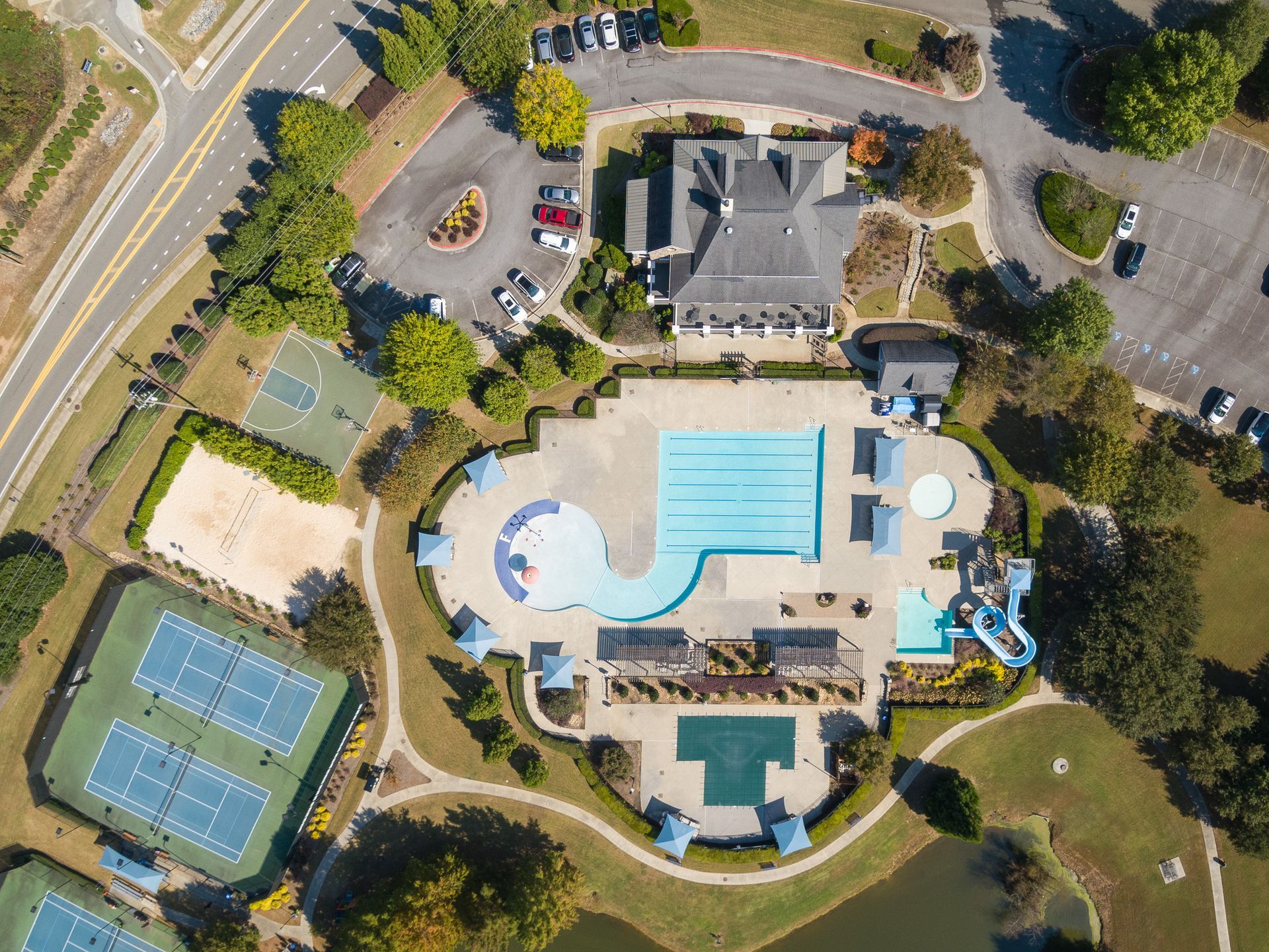 An aerial view of a swimming pool and tennis courts