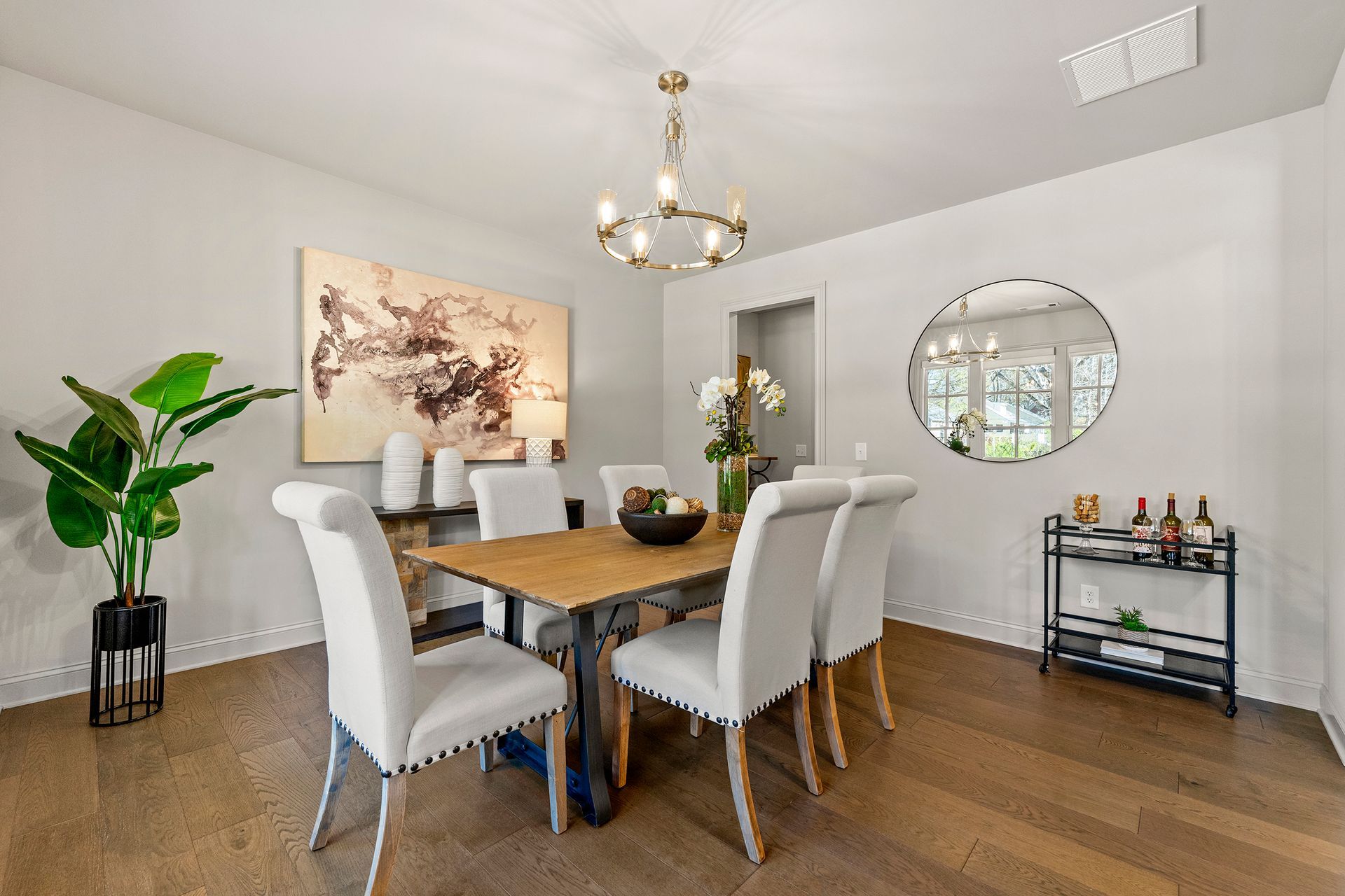 A dining room with a wooden table and white chairs.