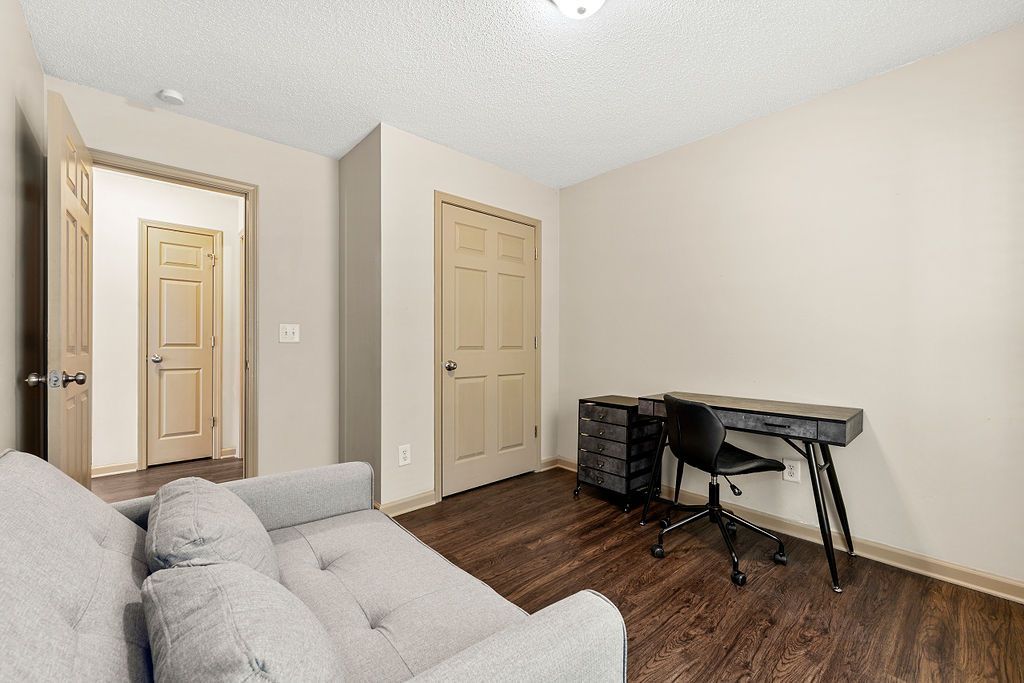 A living room with a couch , desk and chair.