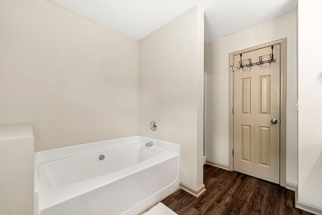 A bathroom with a bathtub and a door.