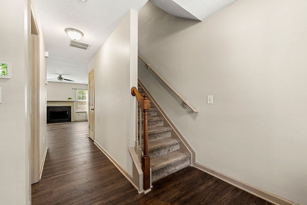 A hallway with stairs leading up to the second floor of a house.