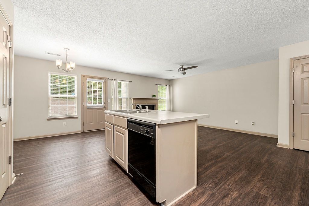 An empty kitchen with a large island in the middle of the room.