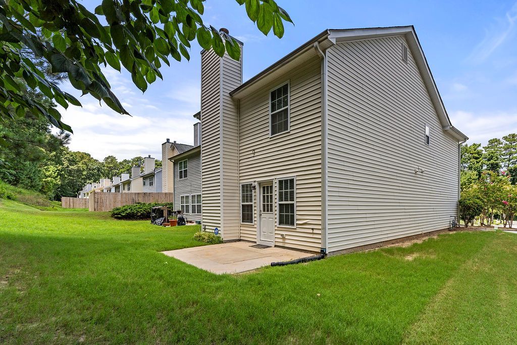 A large house with a lot of windows is sitting on top of a lush green field.