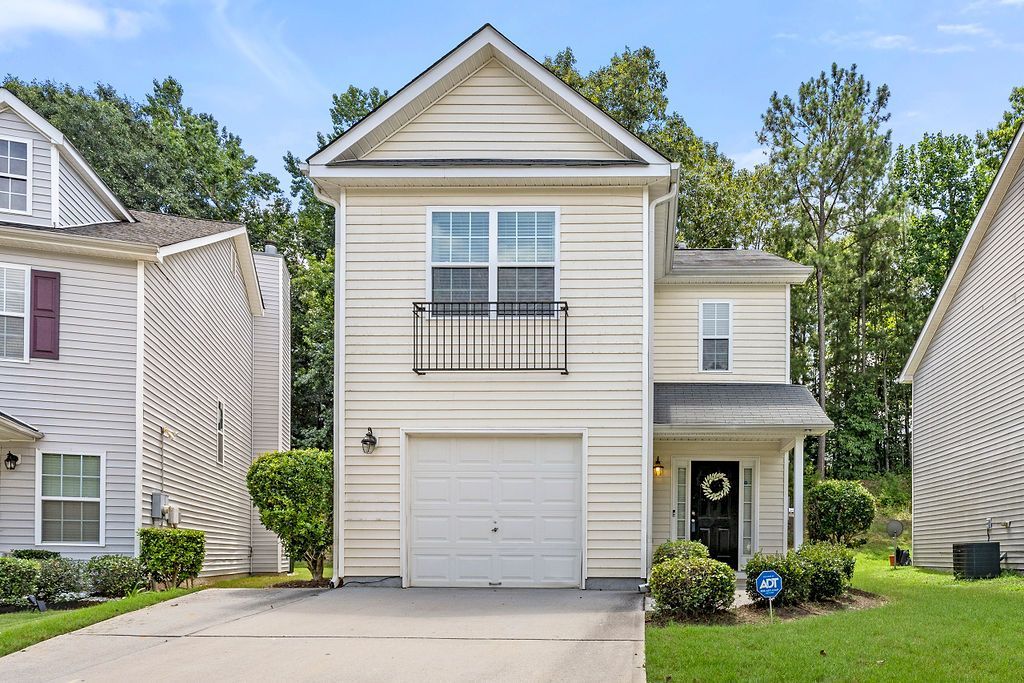 A white house with a balcony and a white garage door
