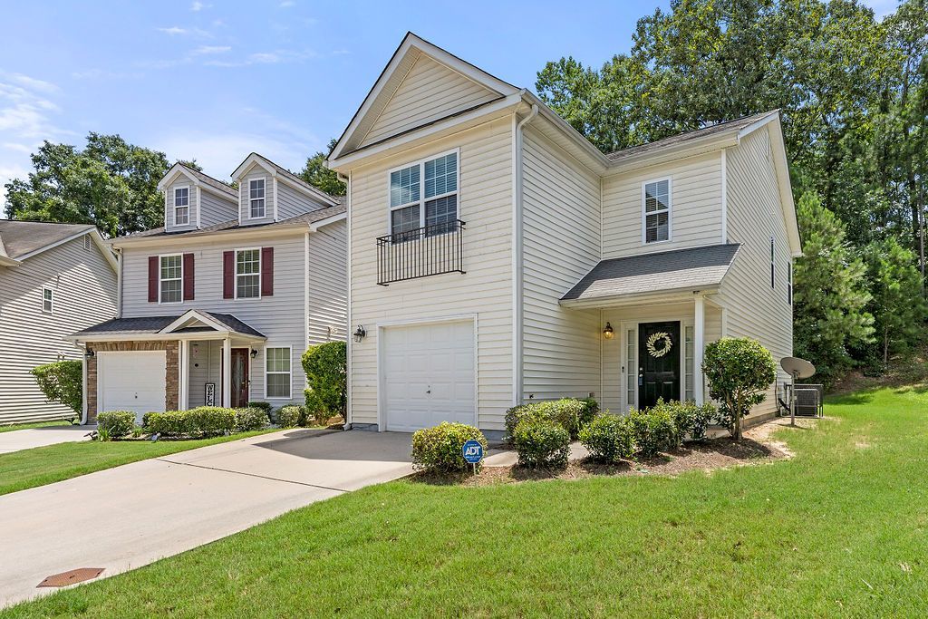 A large white house with a lot of windows and a driveway.