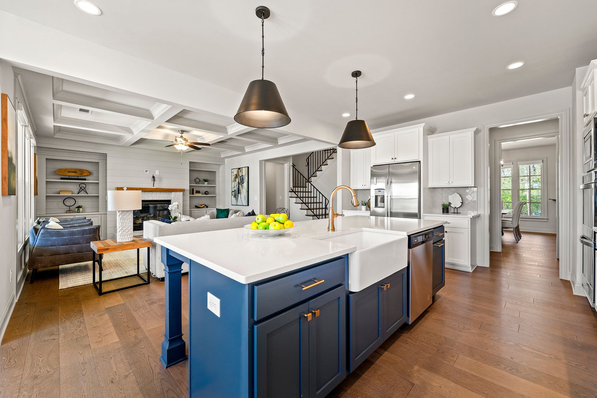 A large kitchen with a blue island , white cabinets , and stainless steel appliances.